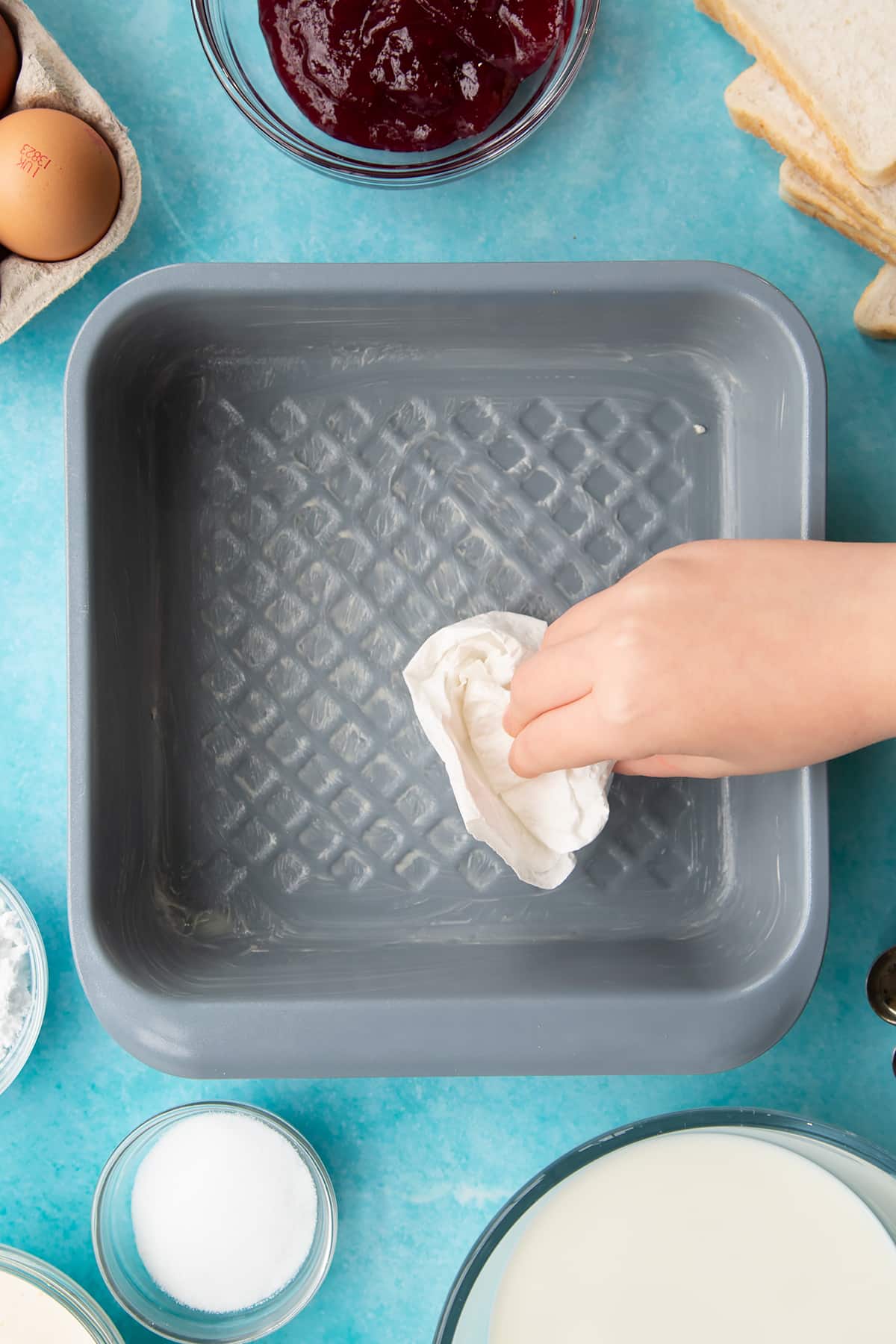 Covering a baking tin in butter.