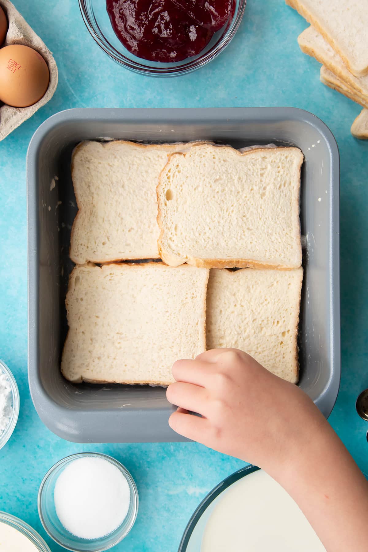 Layering the bread into the baking dish.