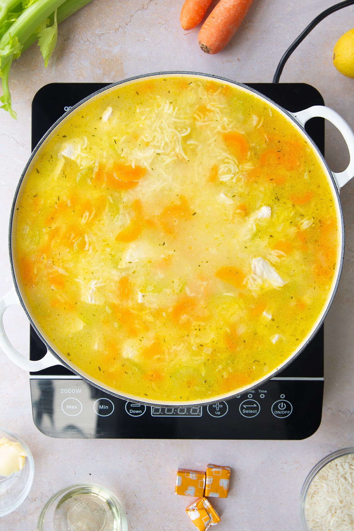 Overhead shot of the turkey rice soup in a pan on the hob.