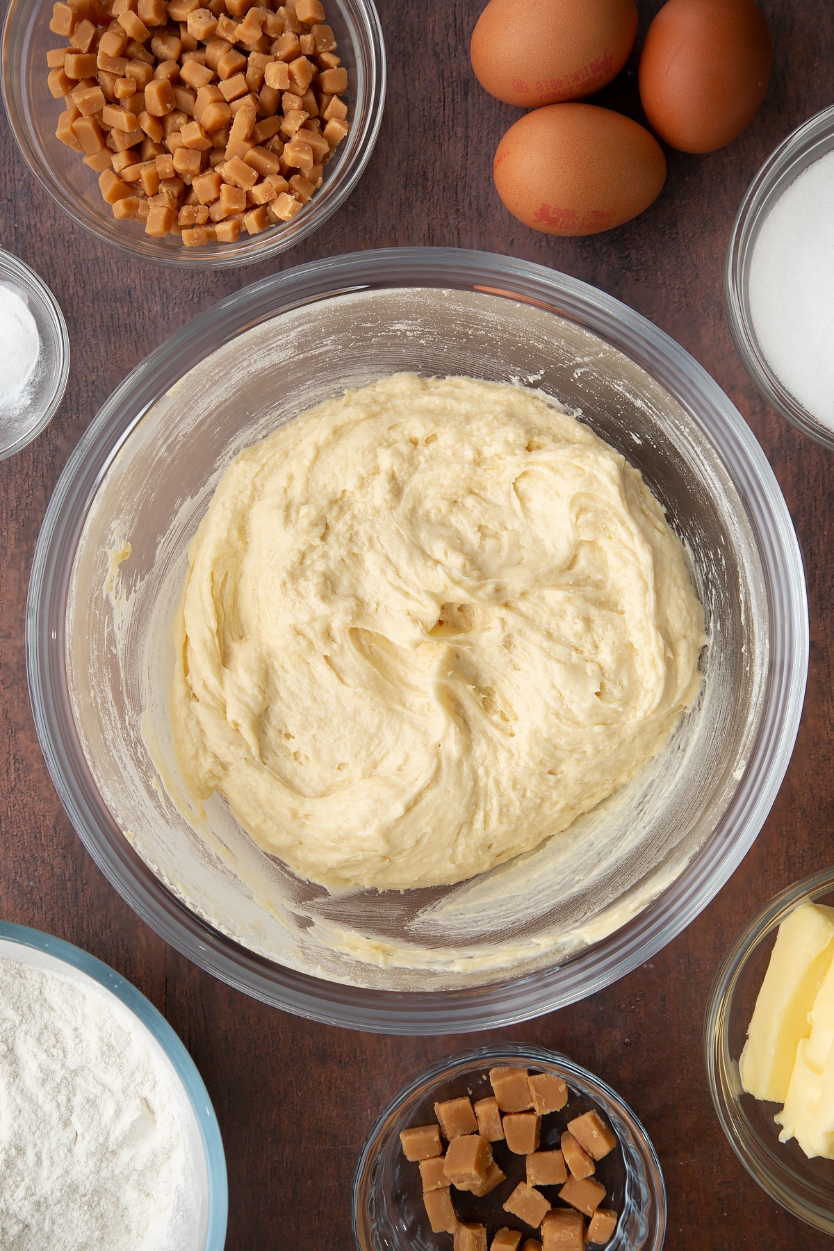 Vanilla cake batter mixture in a large clear bowl.