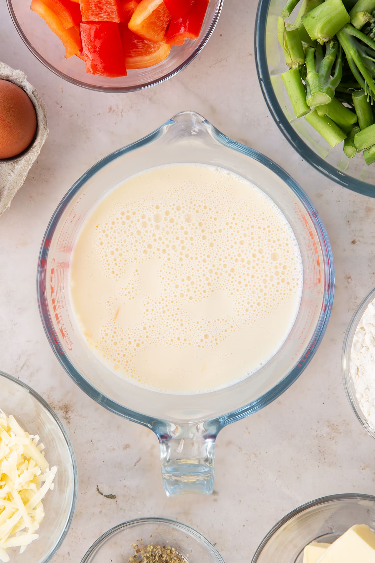 Eggs and milk whisked together in a jug.