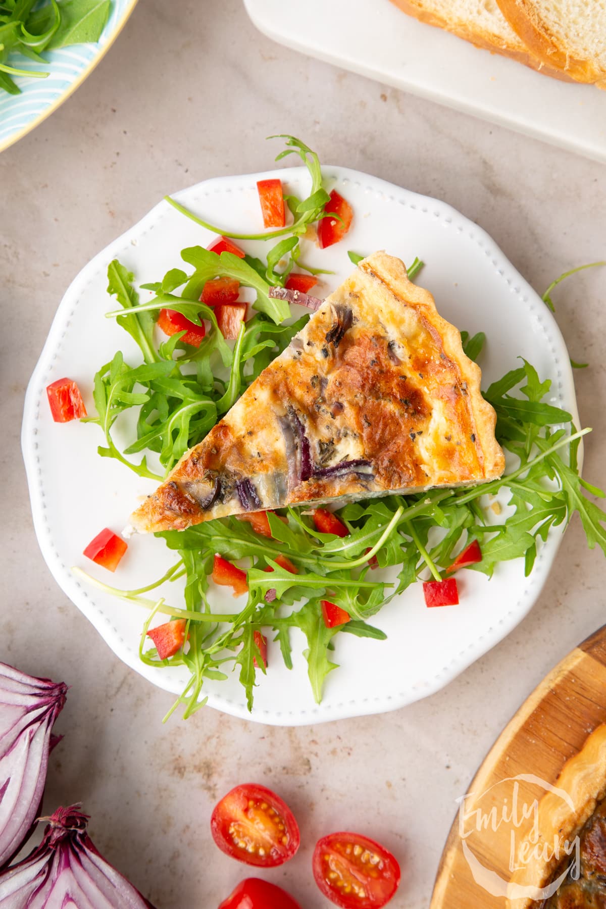 Close up overhead image of a slice of chestnut quiche served over a bed of salad.
