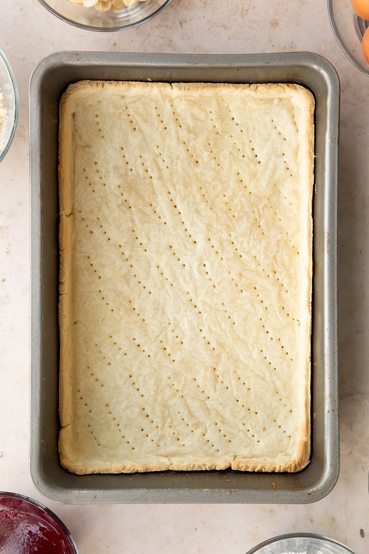 Part-cooked pastry in a rectangular tin.