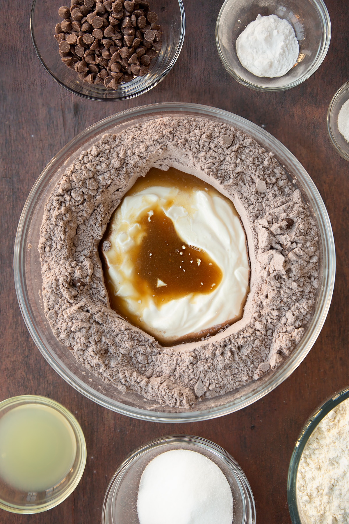 Overhead shot of the wet ingredients being added to the bowl of dry chocolate soda bread ingredients.