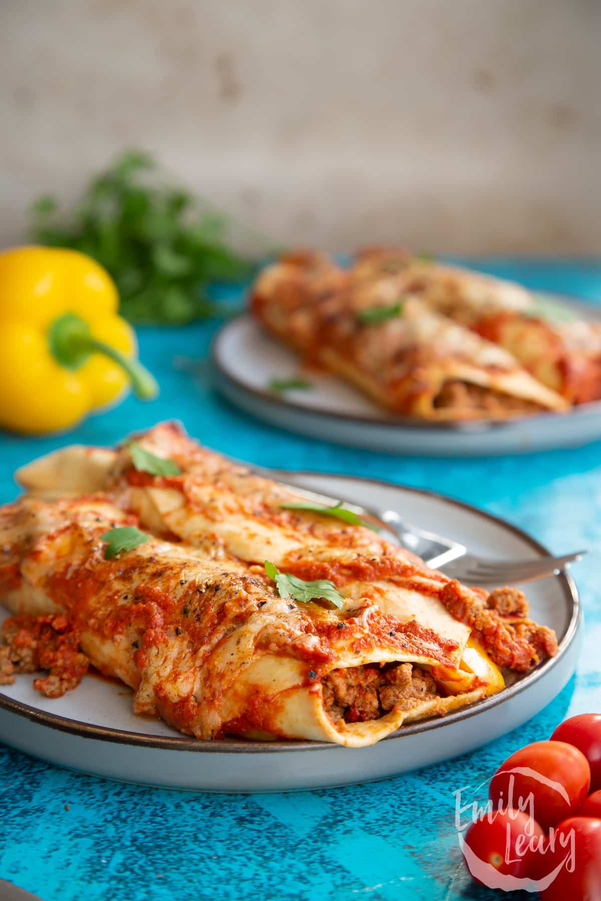 Quorn mince enchiladas served on a grey plate with a fork.