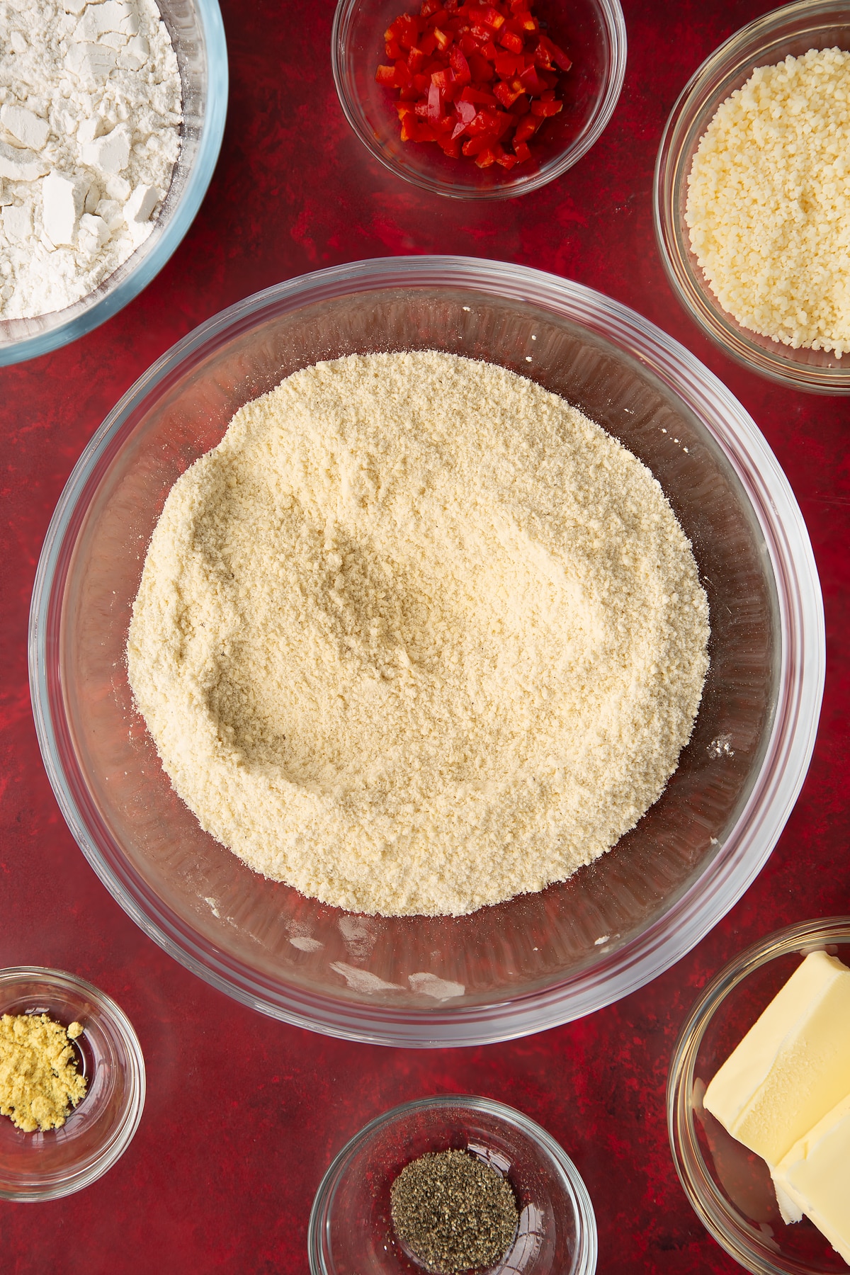 Overhead shot of some of the ingredients required for the spicy cheese straws in a mixing bowl.