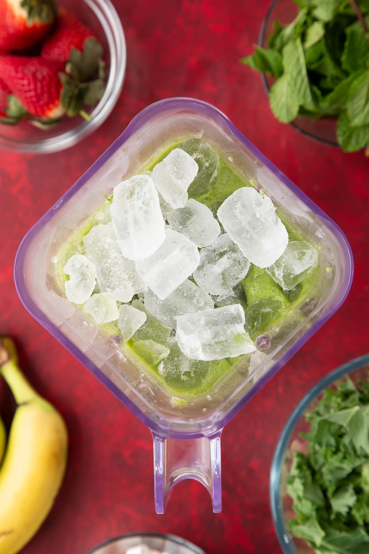 Overhead shot ice being added to the blender.
