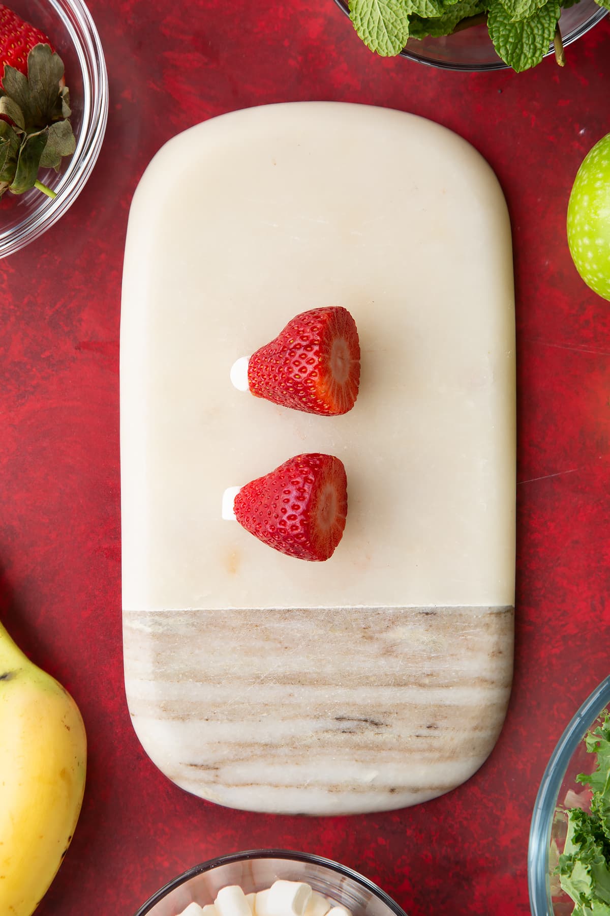 Overhead shot of two strawberries cut with tiny marshmallows on top.