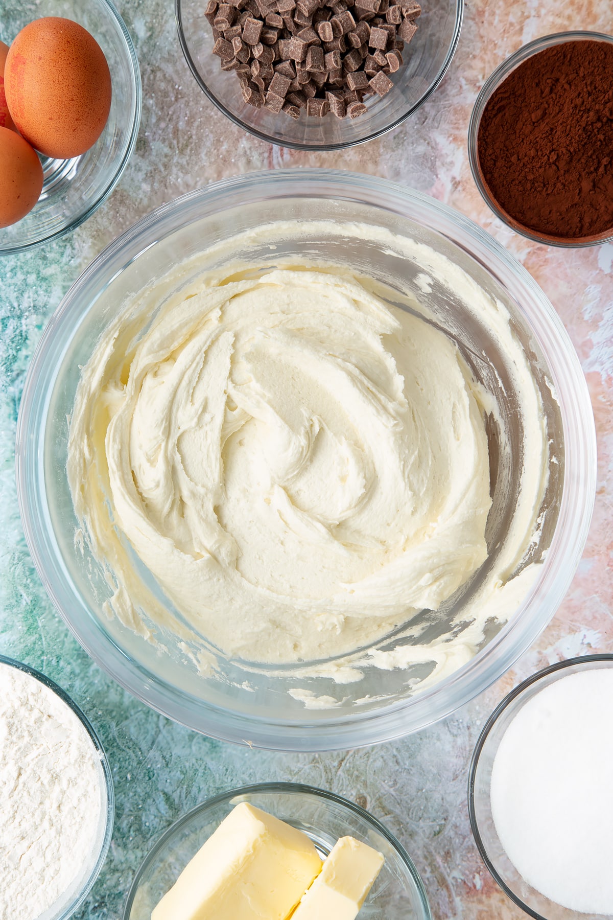Overhead shot of some of the ingredients for the mint choc chip cupcakes frosting mixed together in a mixing bowl.
