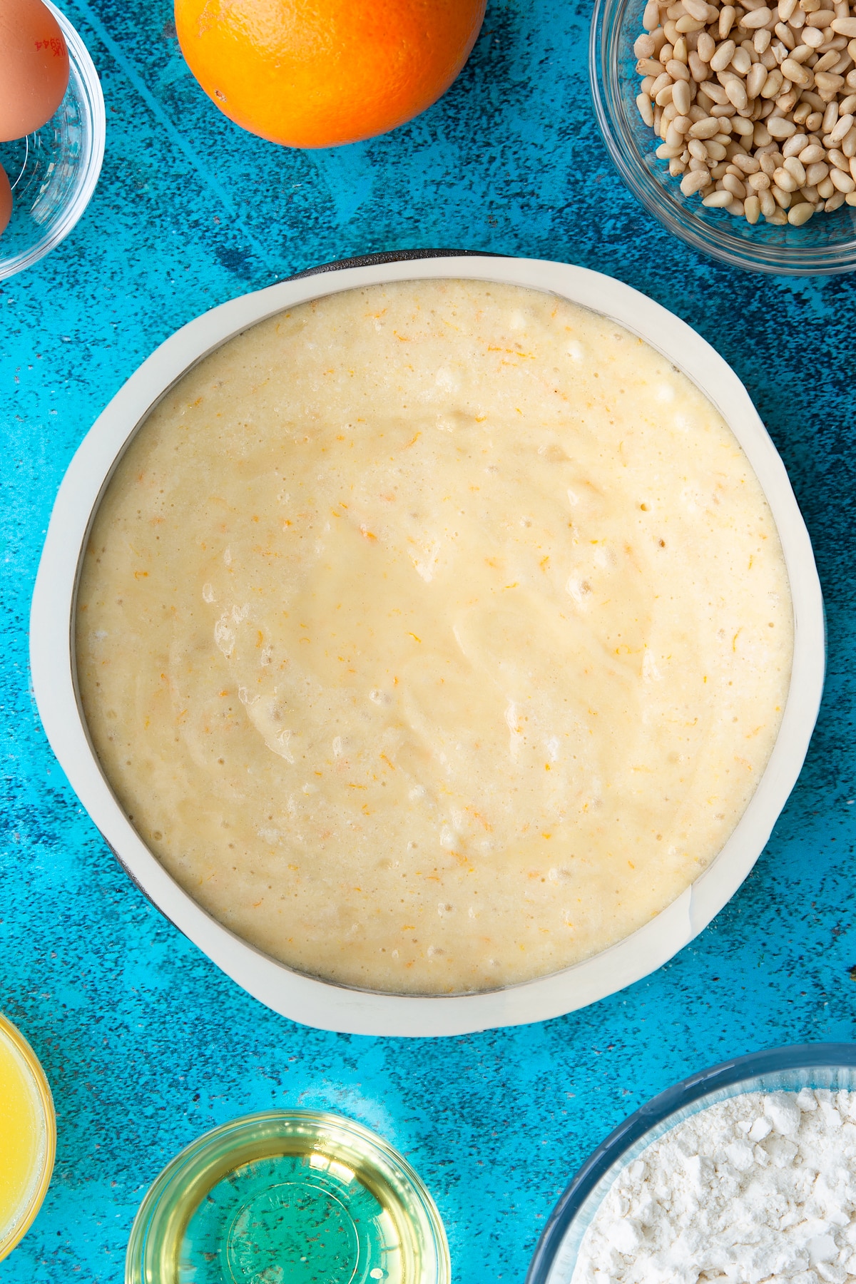 Pine nut cake batter in a lined tin ready to bake.