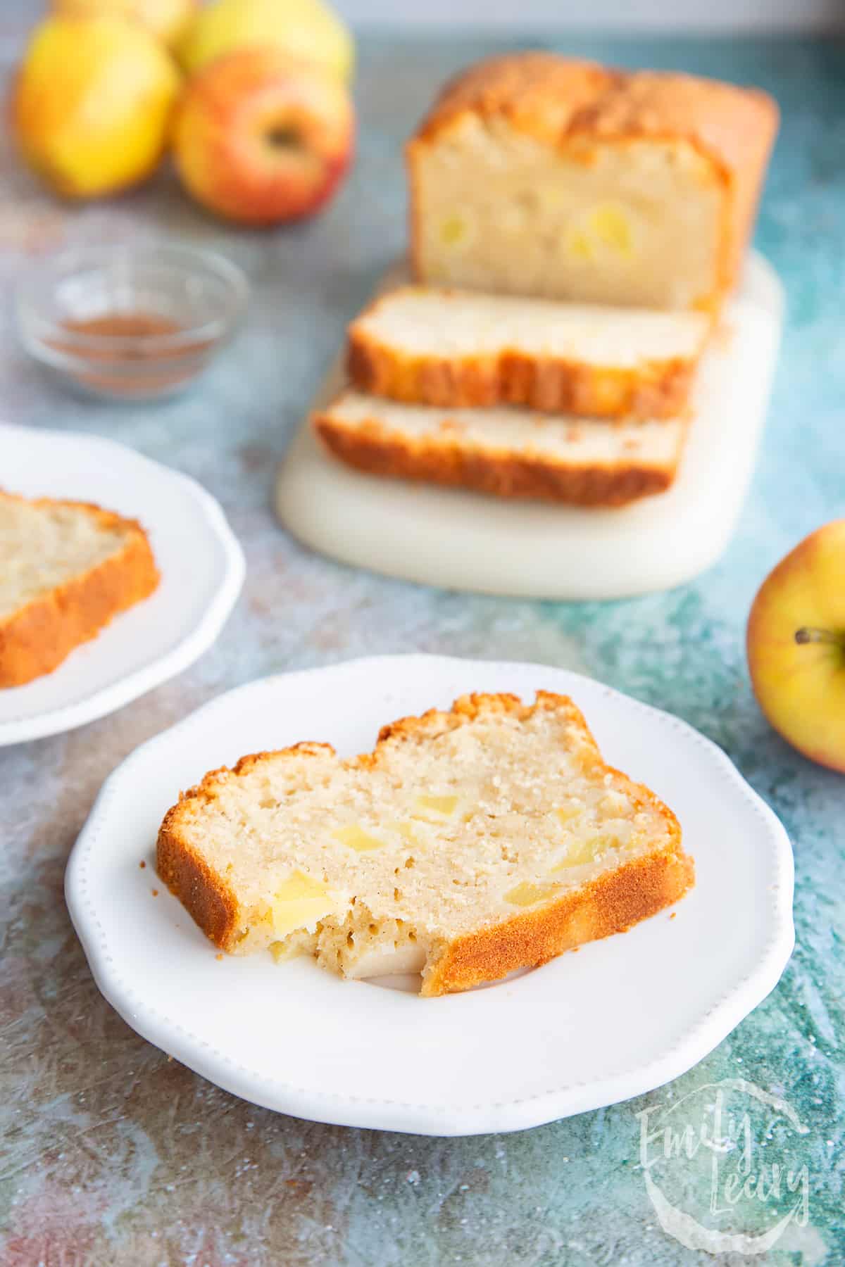 Slice of apple cake on white decorative plate.