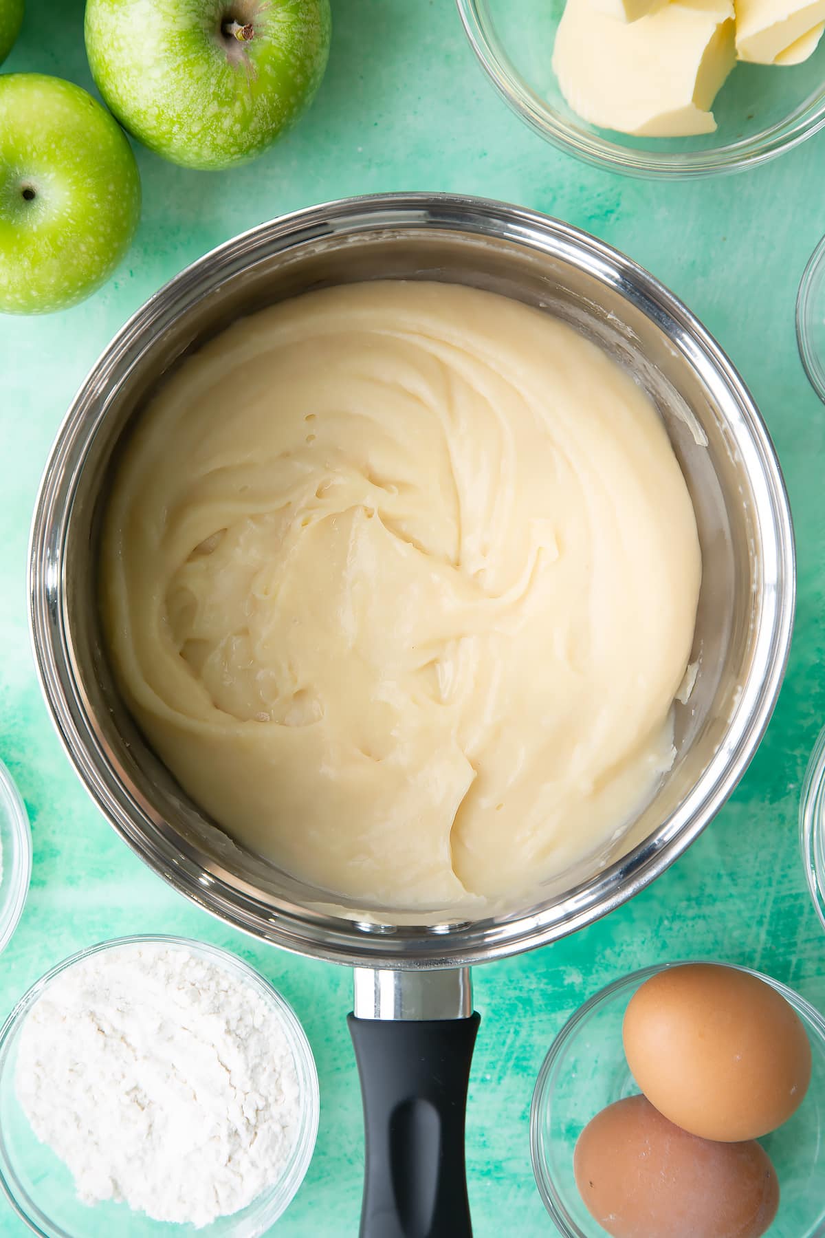Stiring the custard through in the pan until it's thick.