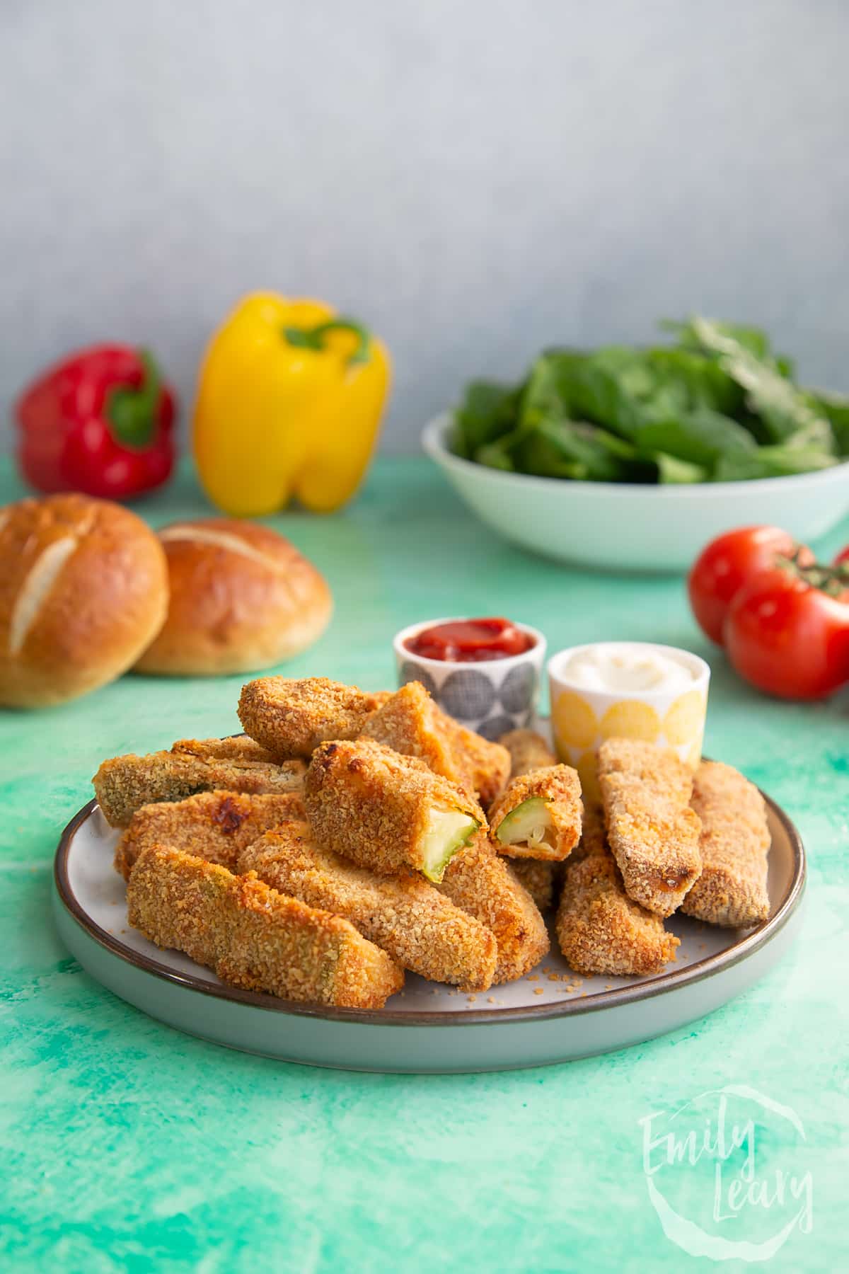 Finished plate of baked courgette fries with one cut open showing the inside.