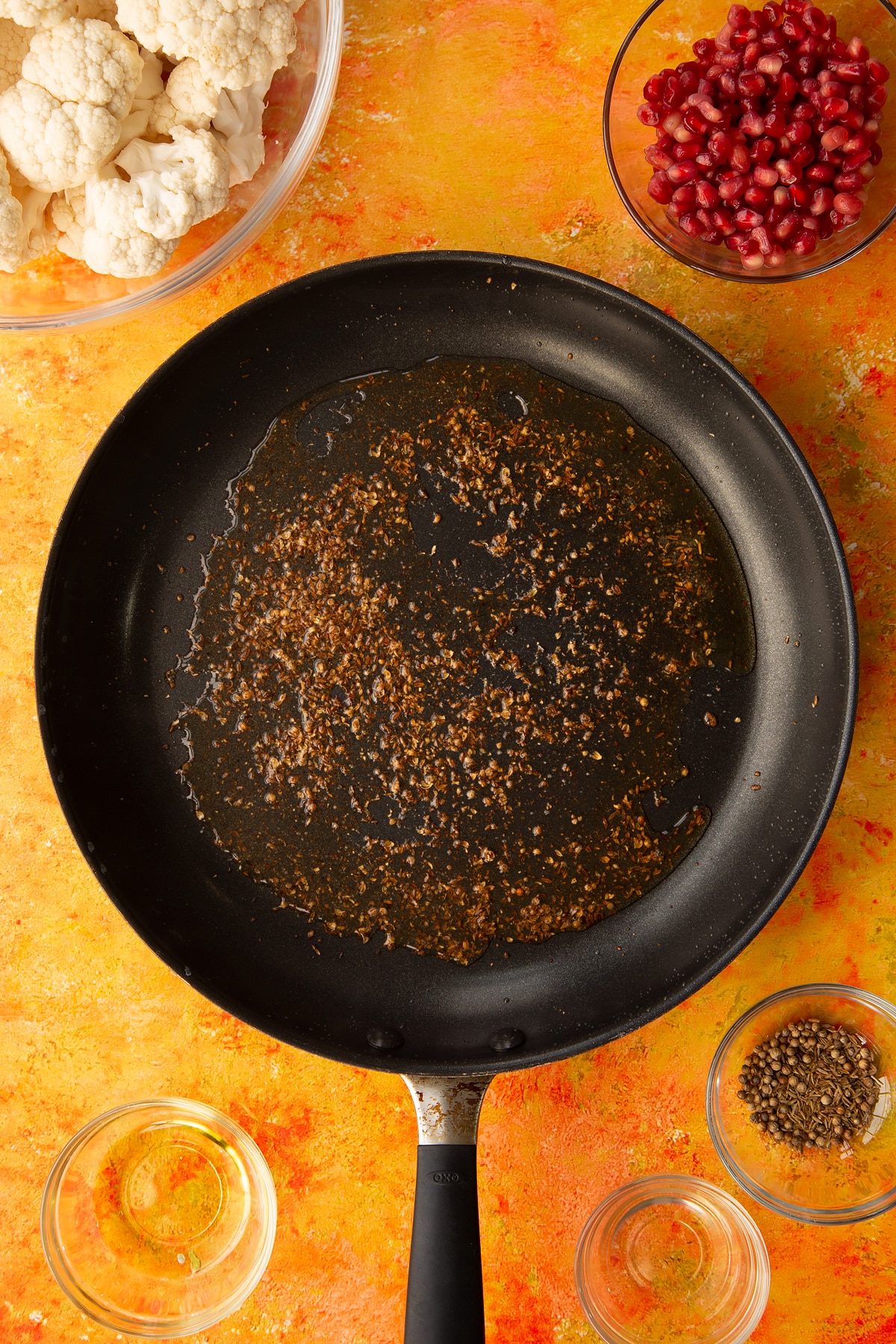 Adding the cumin and corriander seeds to the pan.