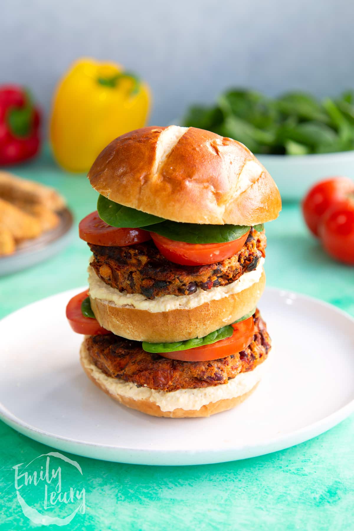 Close up image of a stacked kidney bean burger on a white plate.