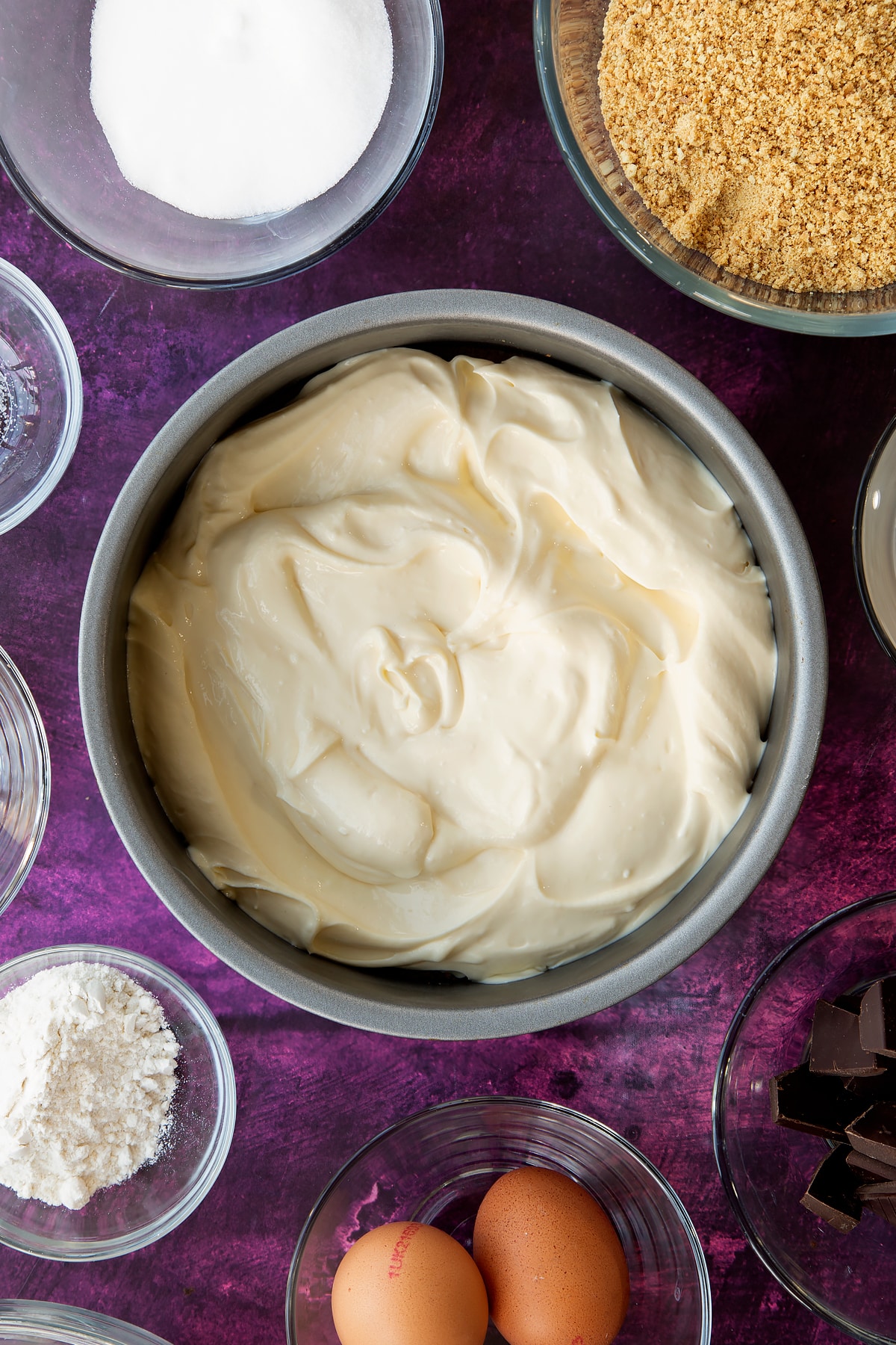 Adding the cream cheese filling to the non-stick cake tin.