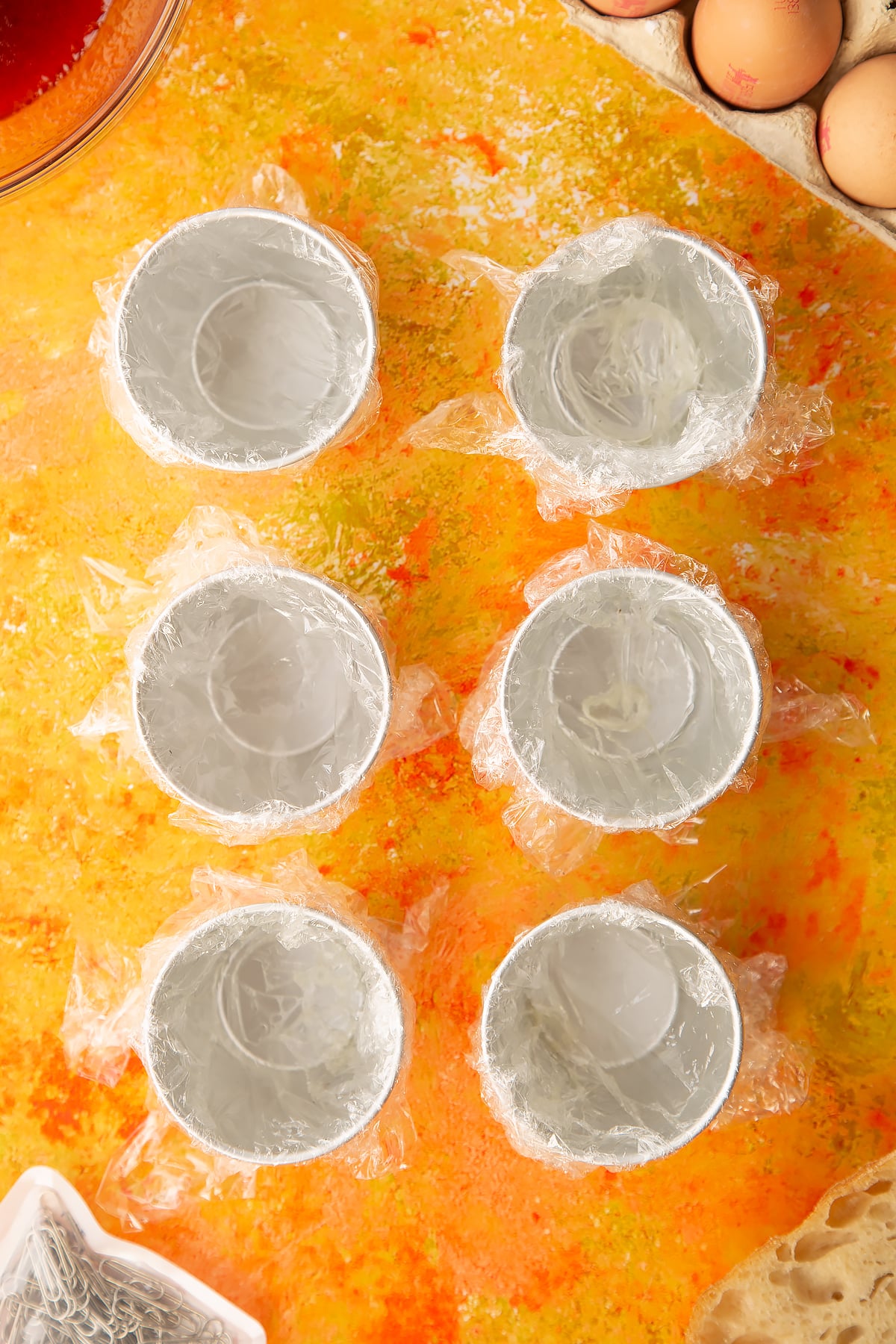 Six small bowls each covered in clingfilm.