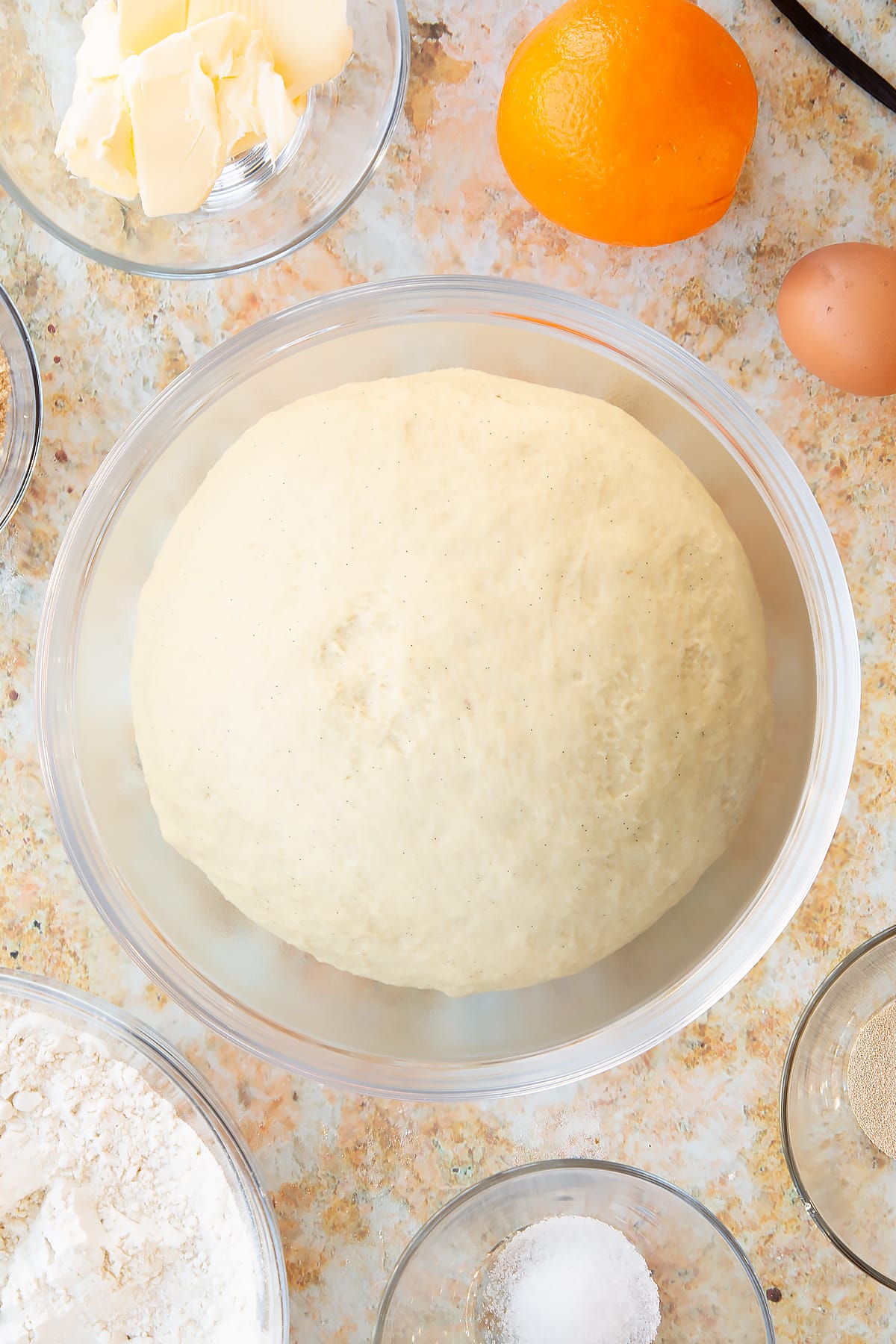 Overhead shot of the spiced fruit buns dough having been left to rise for one to two hours.