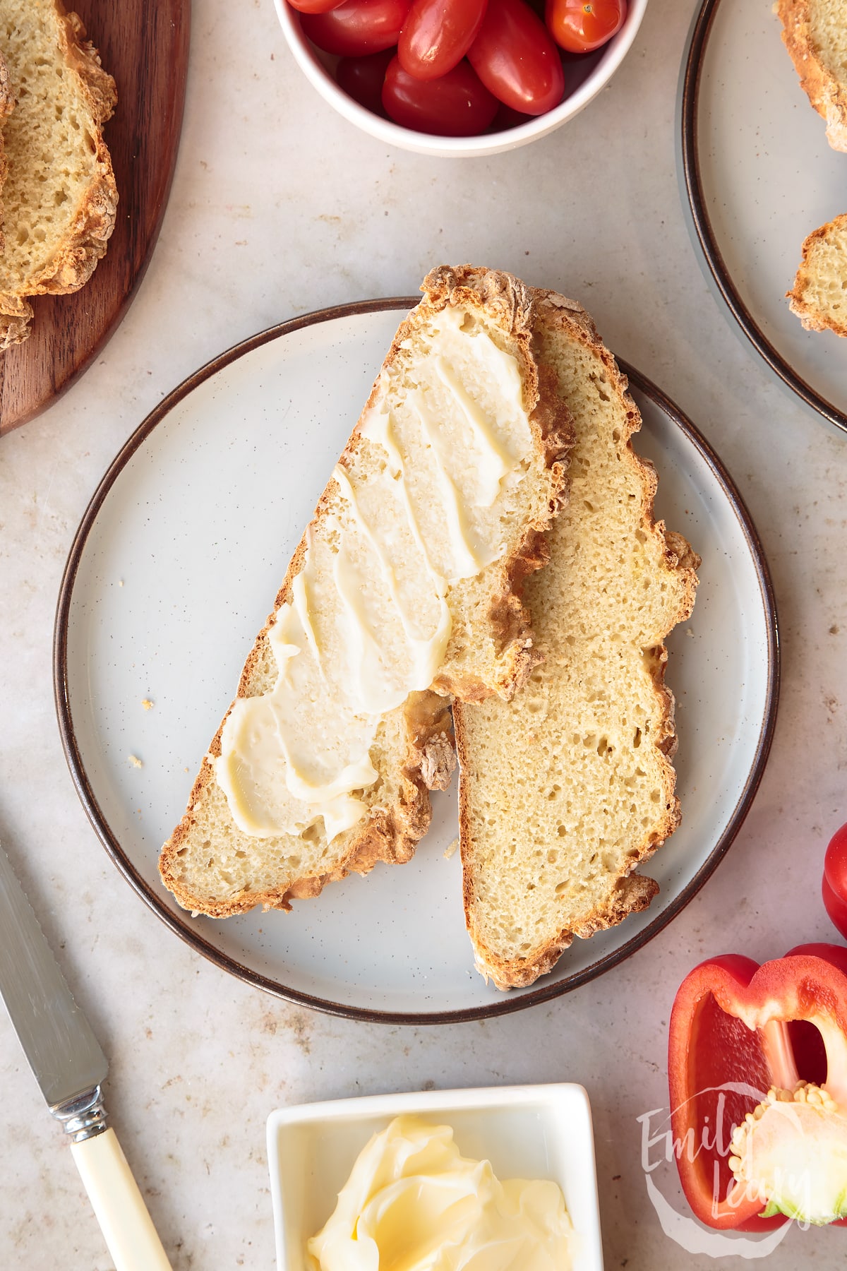 Finished slices of white spelt soda bread. Once slice has been buttered. Both slices are on a decorative plate.