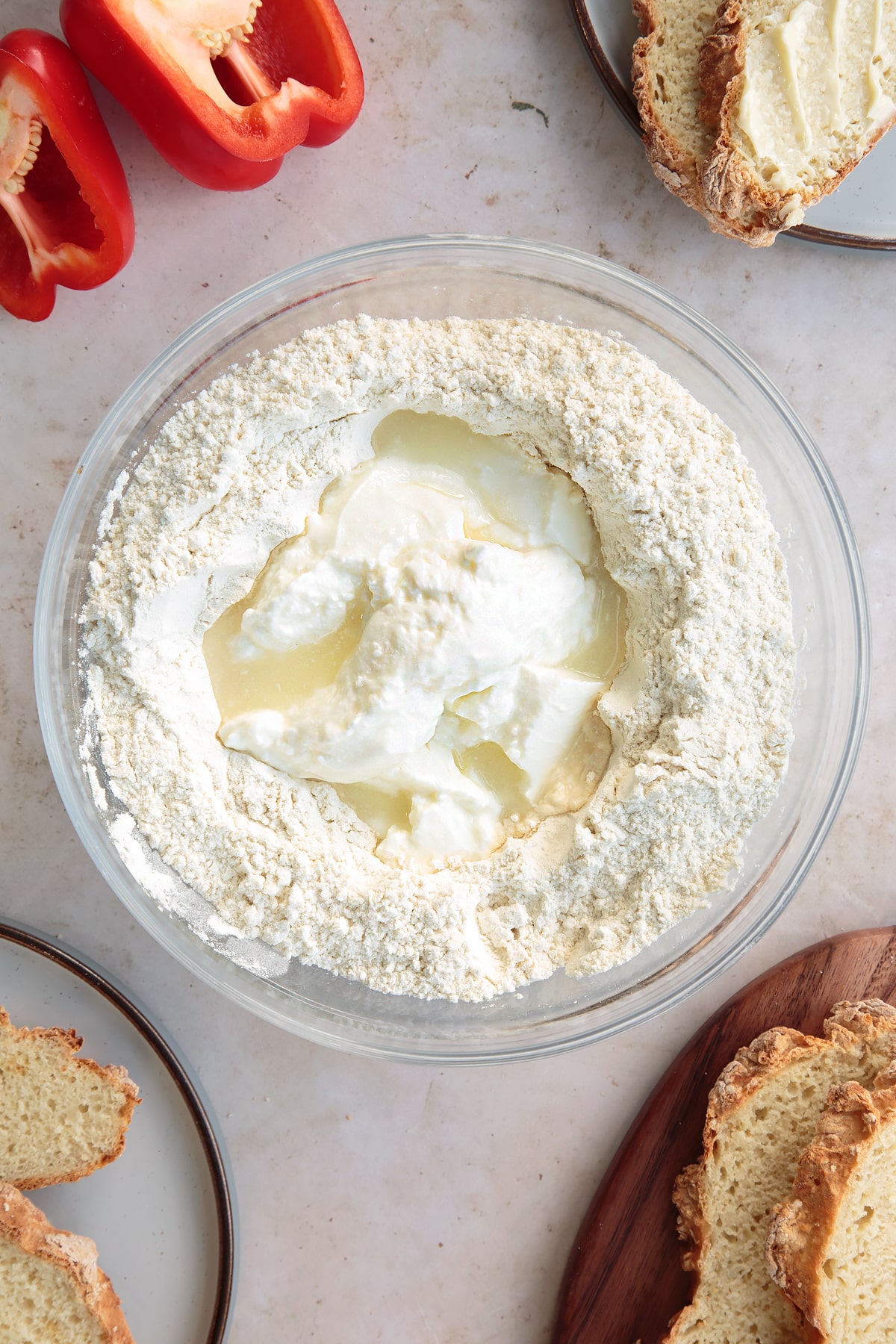 Adding the yogurt and lemon juice to the bowl of white spelt soda bread ingredients.