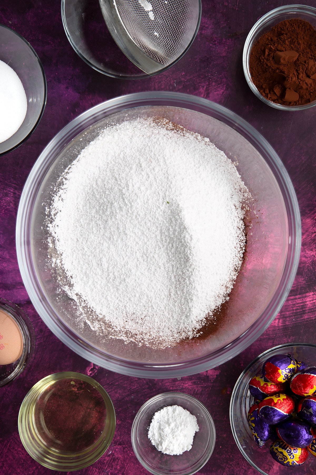 Sifting flour, icing sugar, baking powder and cocoa powder into the mixing bowl.