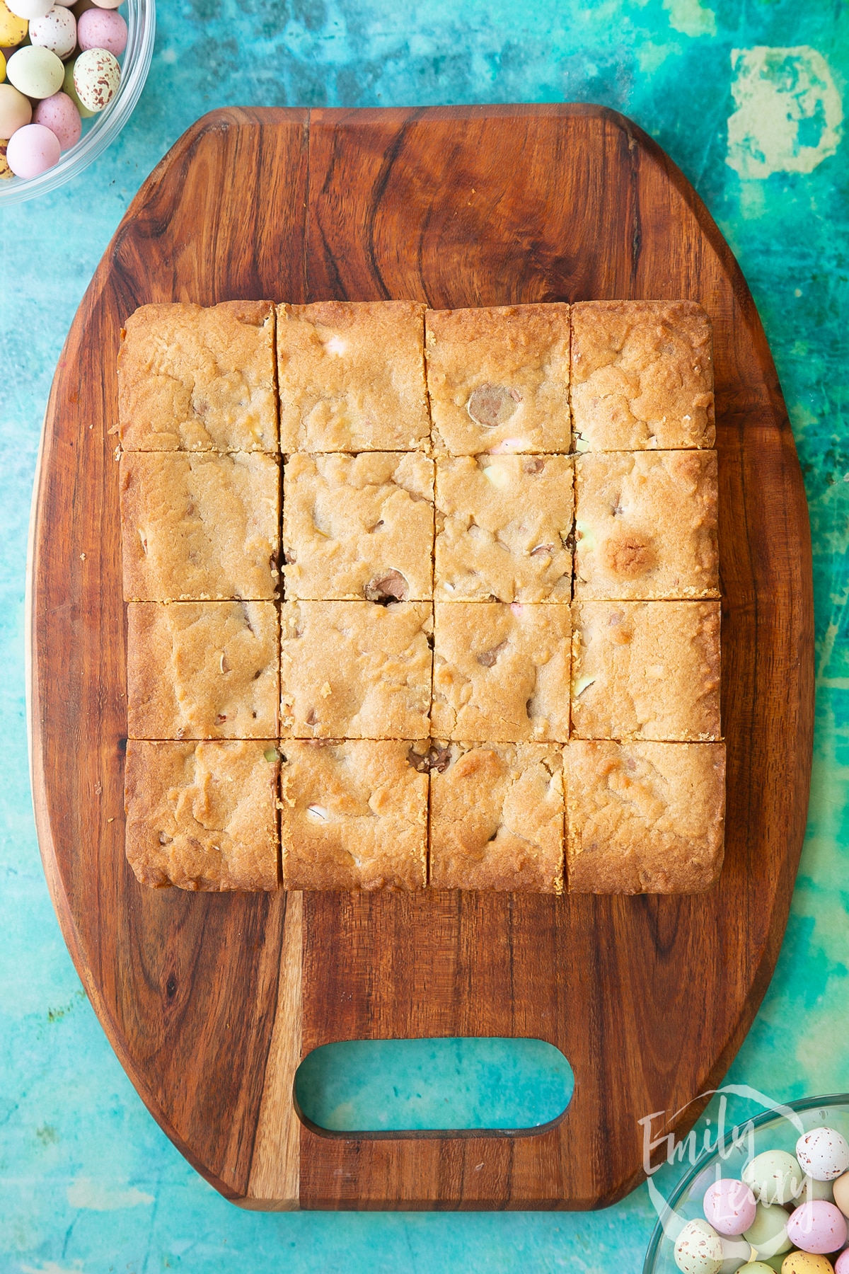Overhead shot of the cookie bar having been cut into 16 squares on a wooden board.