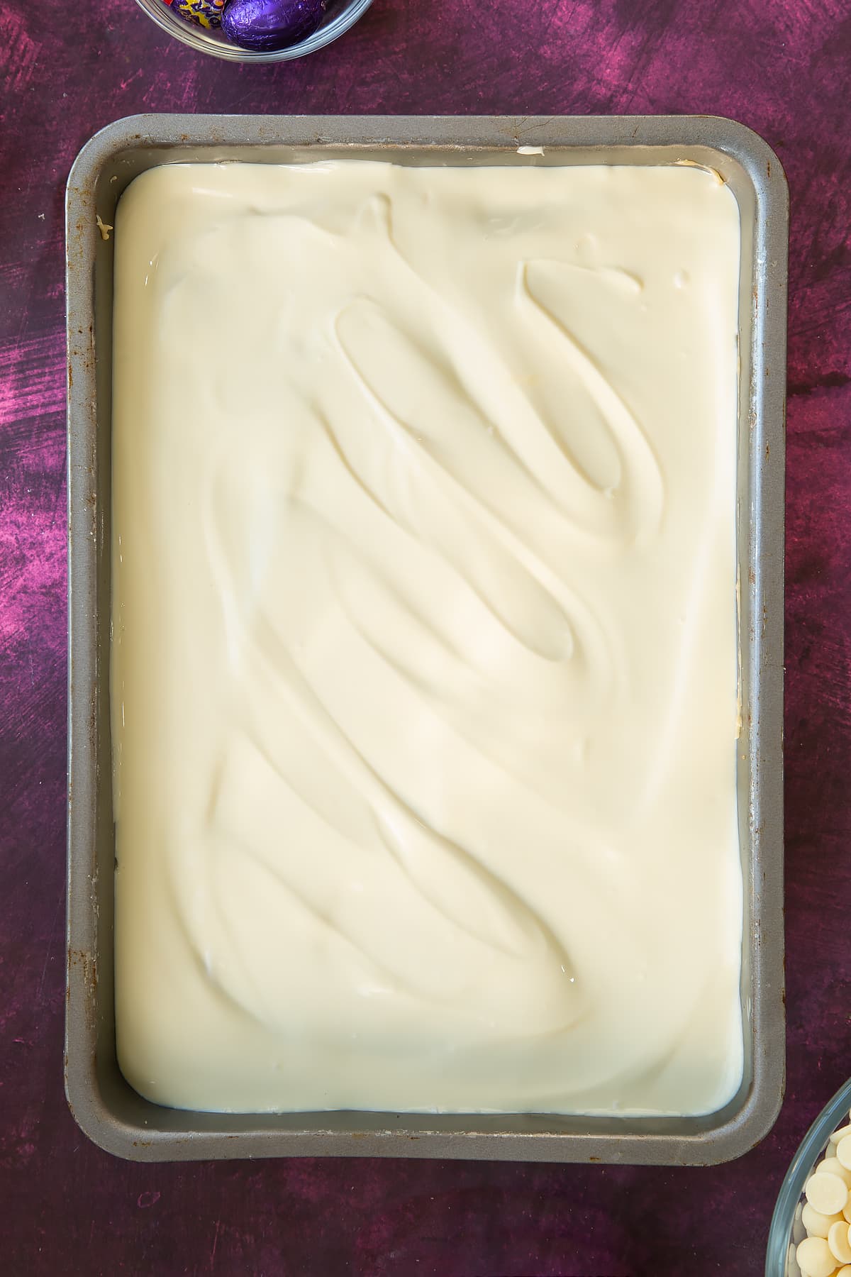Baking tin having had the white chocolate poured and smoothed across the top.