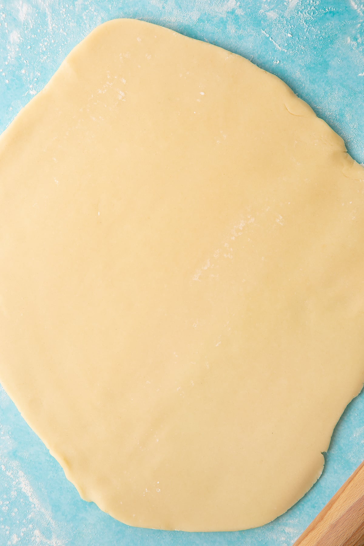 Cookie dough rolled out across a surface.