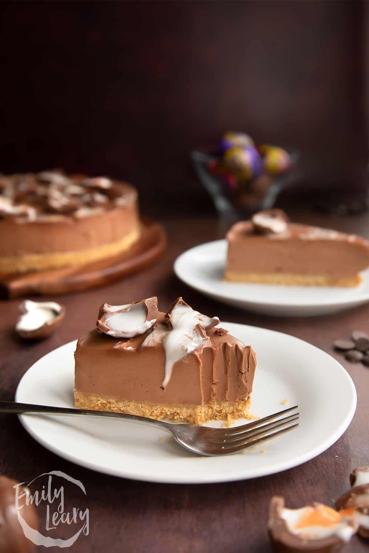 Side on shot of a slice of Cadbury Creme Egg cheesecake after a fork has taken away a small piece.