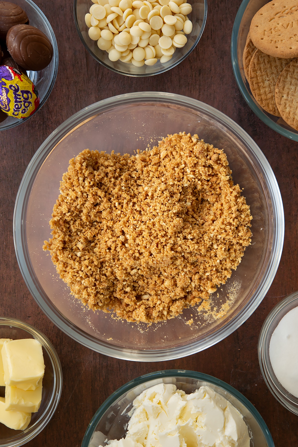 Mixing together the bowl of crumbled biscuits and butter.