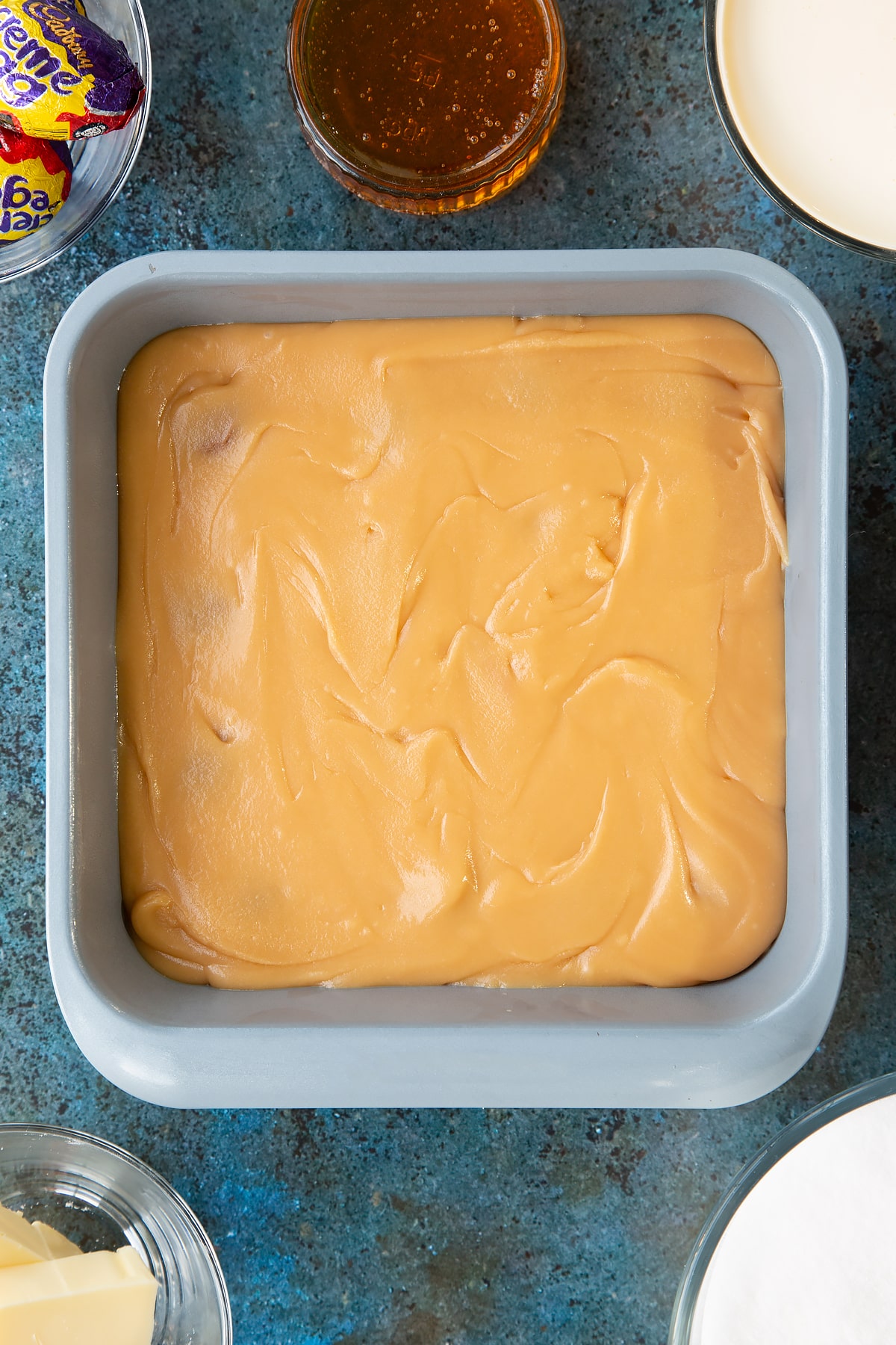 Overhead shot of the remaining fudge having been poured over the top of the 16 Creme eggs.