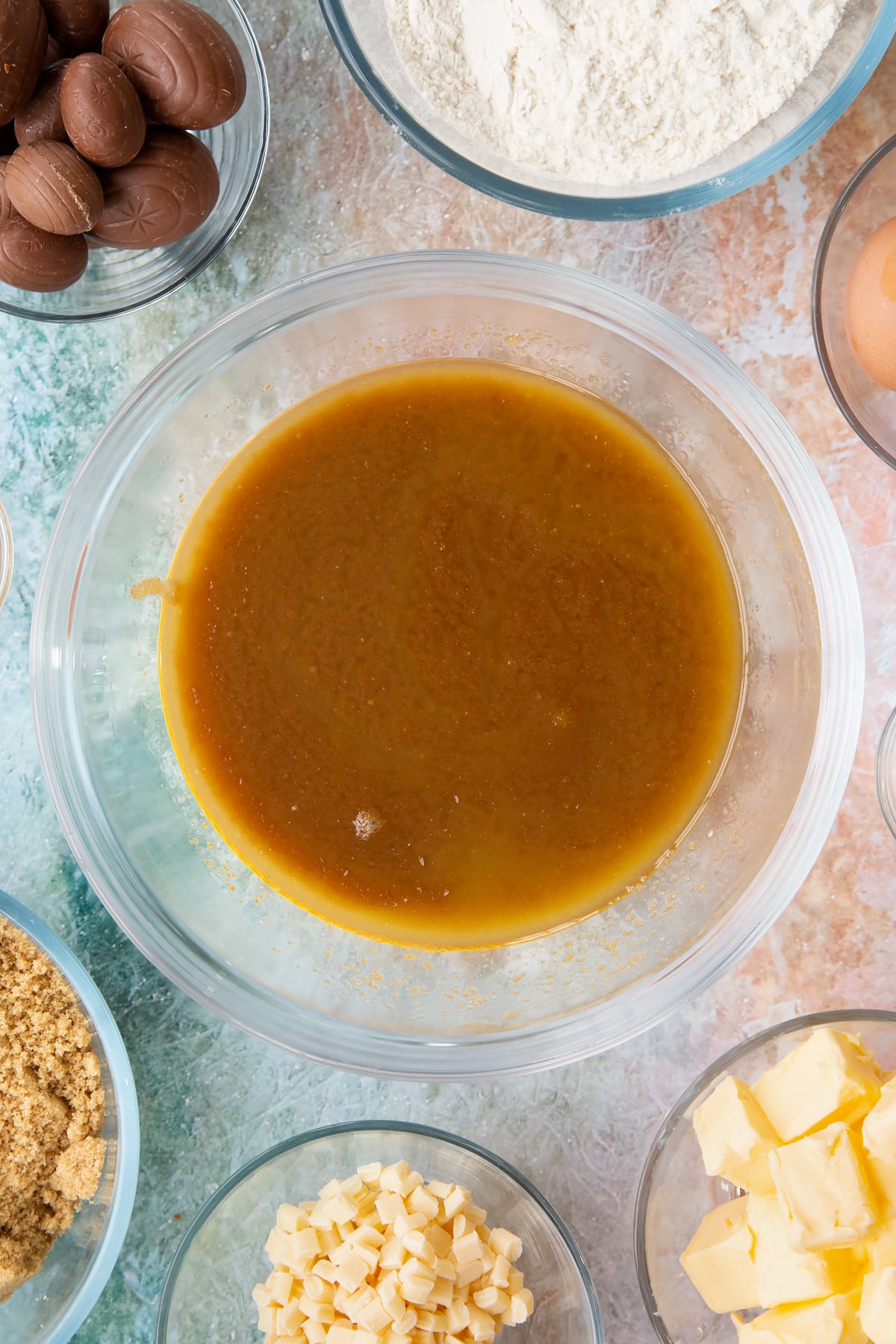 Overhead shot of a mixing bowl with melted butter and brown sugar mixed together.