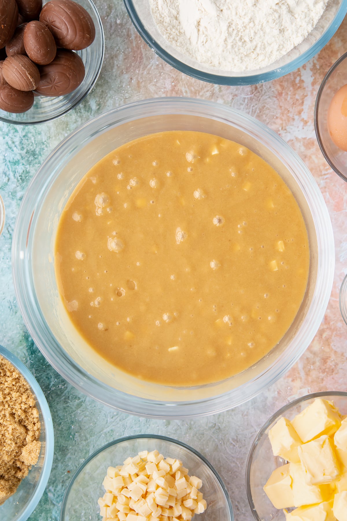 Mixing the white chocolate chips into the bowl of easter blondies wet mixture.