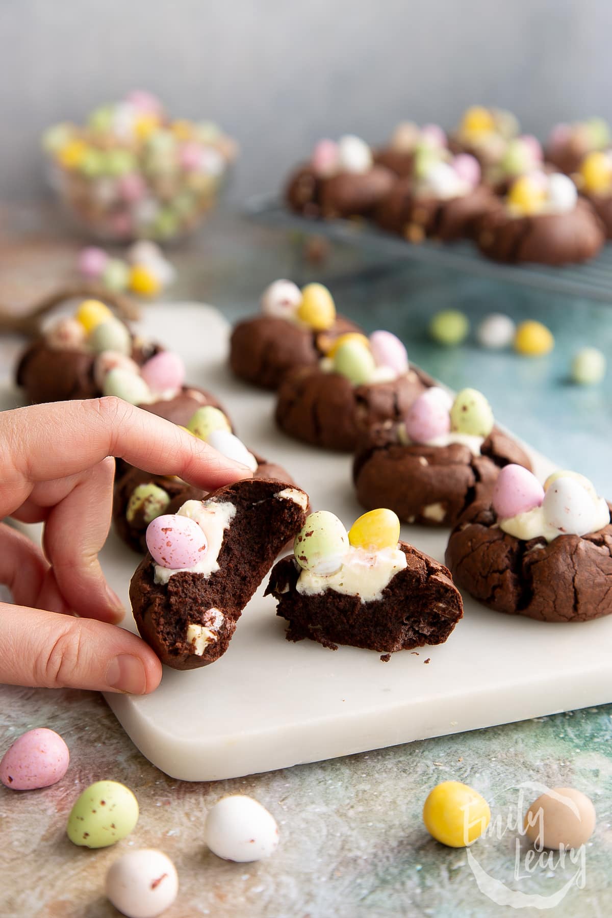 Hand holding a cut open Easter cheesecake cookie.