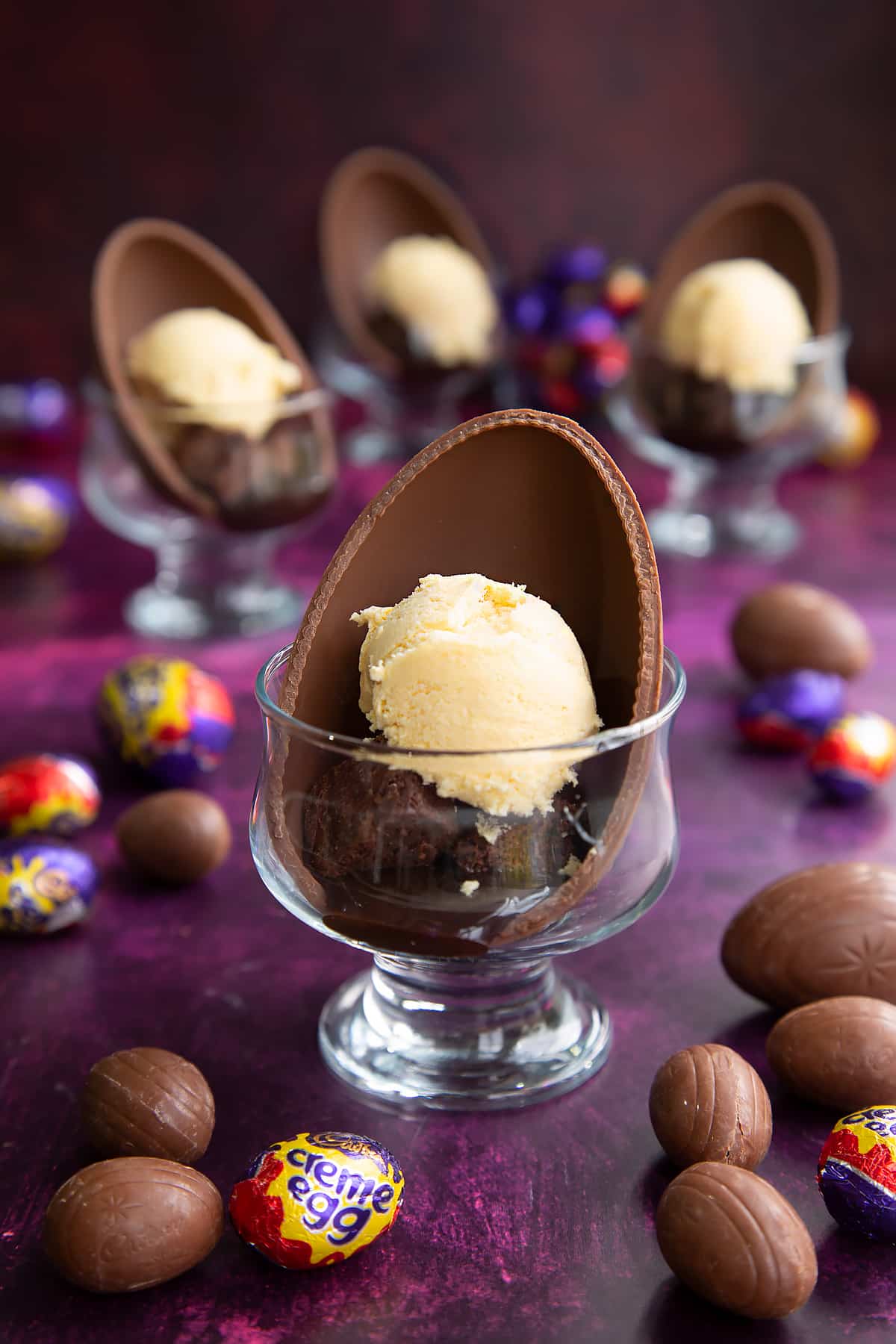 Adding scoops of ice cream ontop of the brownie bites inside the Easter egg half.