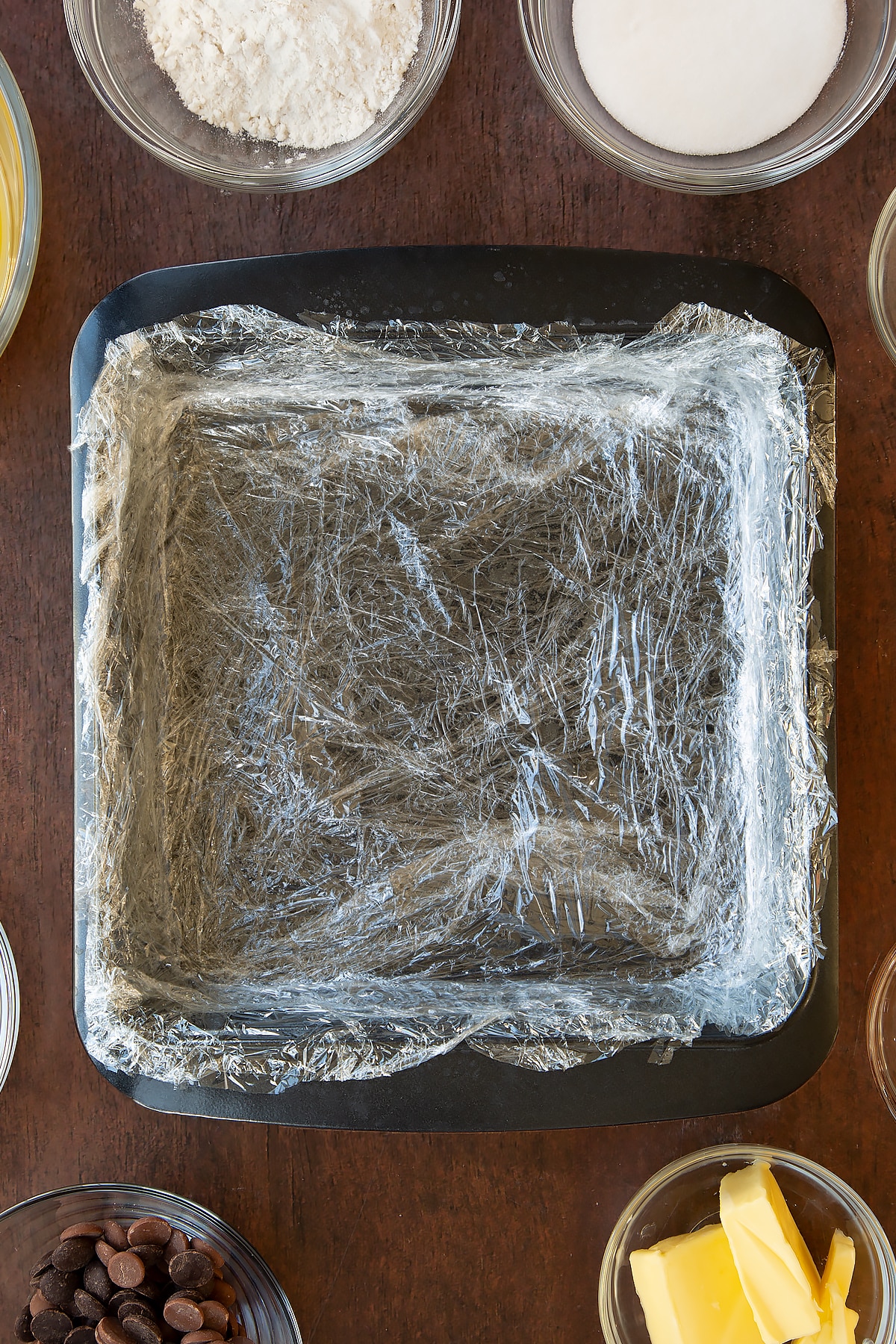 Square baking tin lined with cling film.