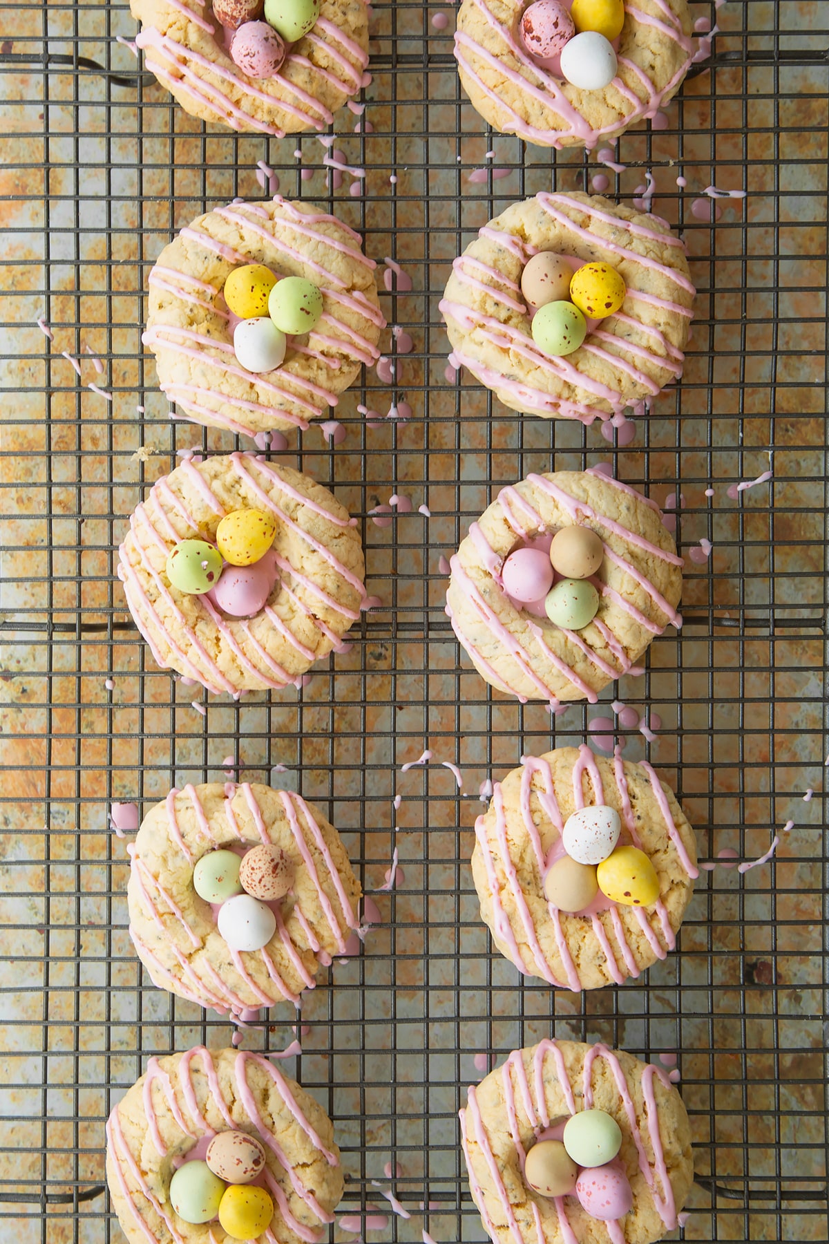 Adding the mini eggs ontop of the icing sugar in the well of the cookies.