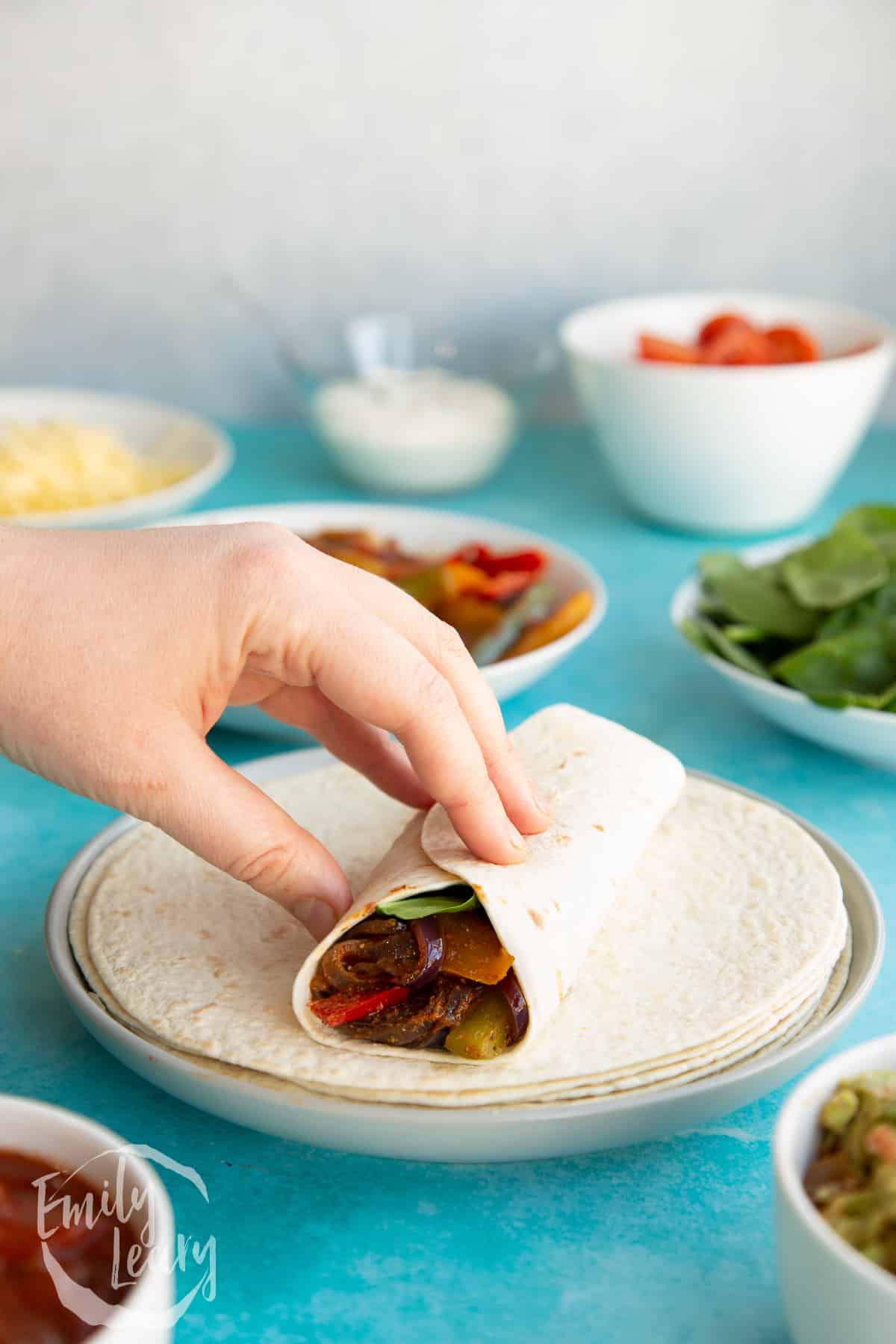 Folded veggie fajita with under tortillas underneeth.