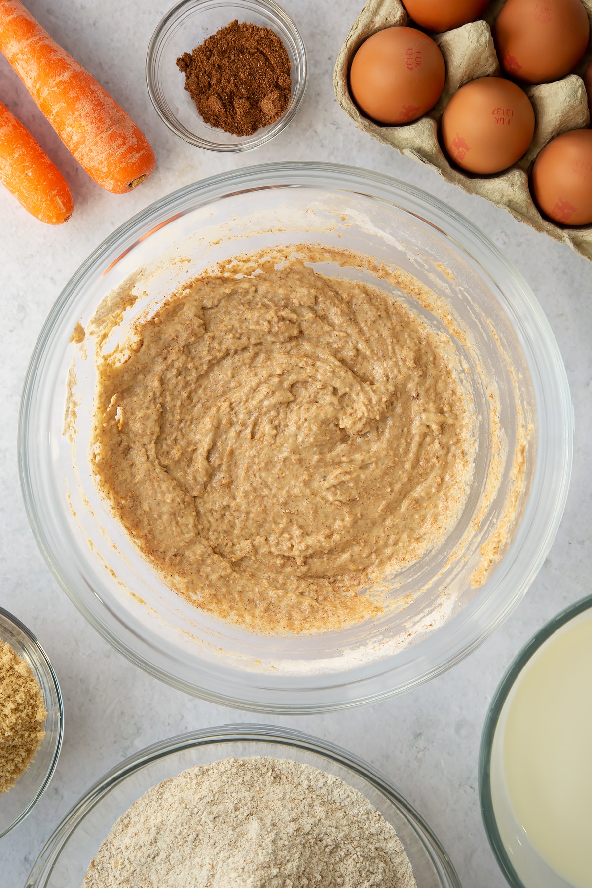 whisked egg, sugar and flour mixture in a large clear bowl with mixed spice.