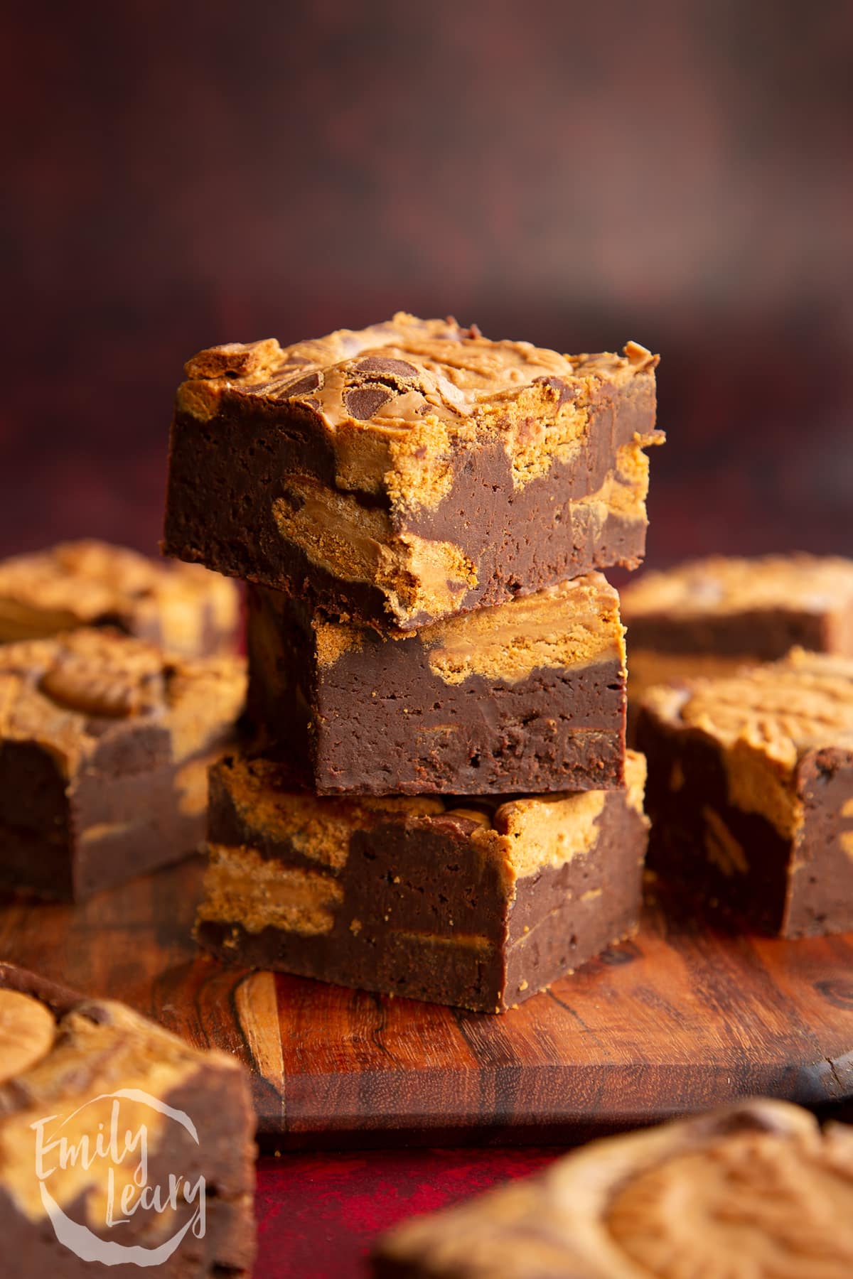 square biscoff brownies stacked on a wooden chopping board
