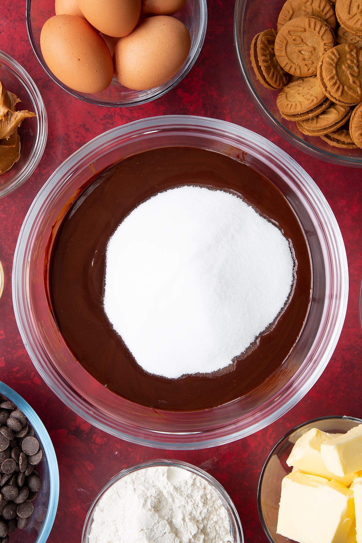 melted butter and chocolate mix topped with sugar in a large clear bowl.