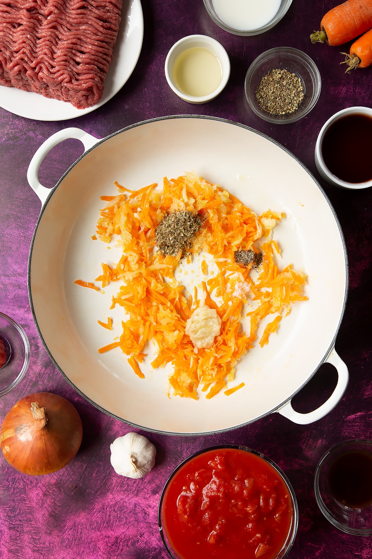 oil, carrot, onion, garlic, oregano in a large white frying pan.