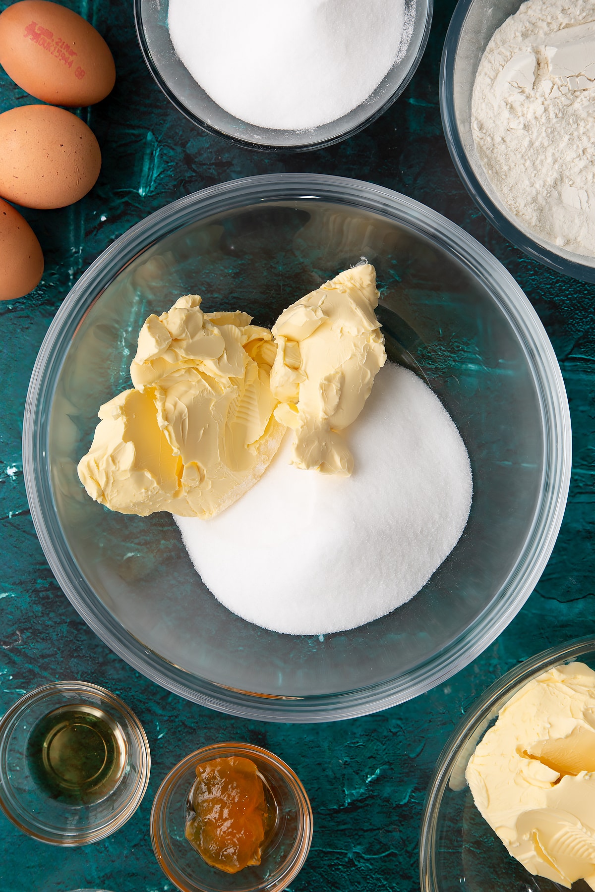 sugar and margarine in a large mixing bowl with ingredients in the background.
