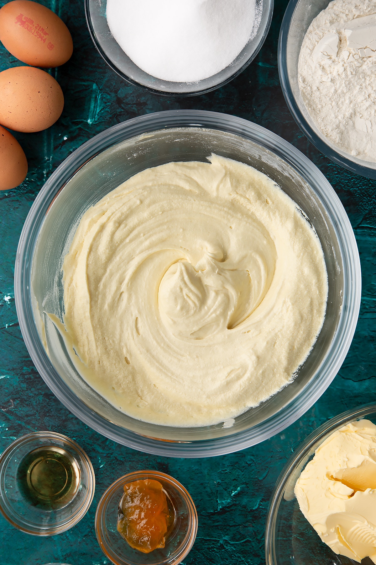 whisked cake batter in a large clear bowl.