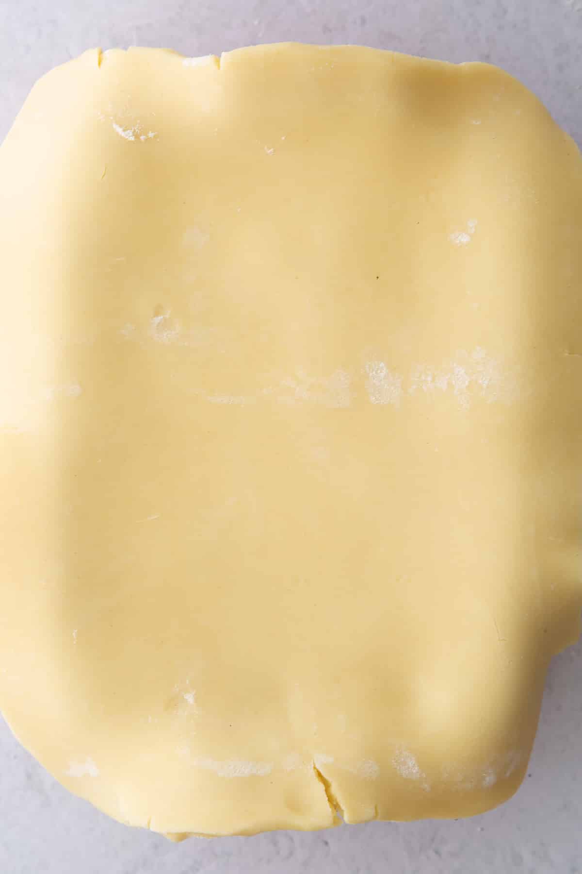 rolled out gluten free pastry on a pale background.