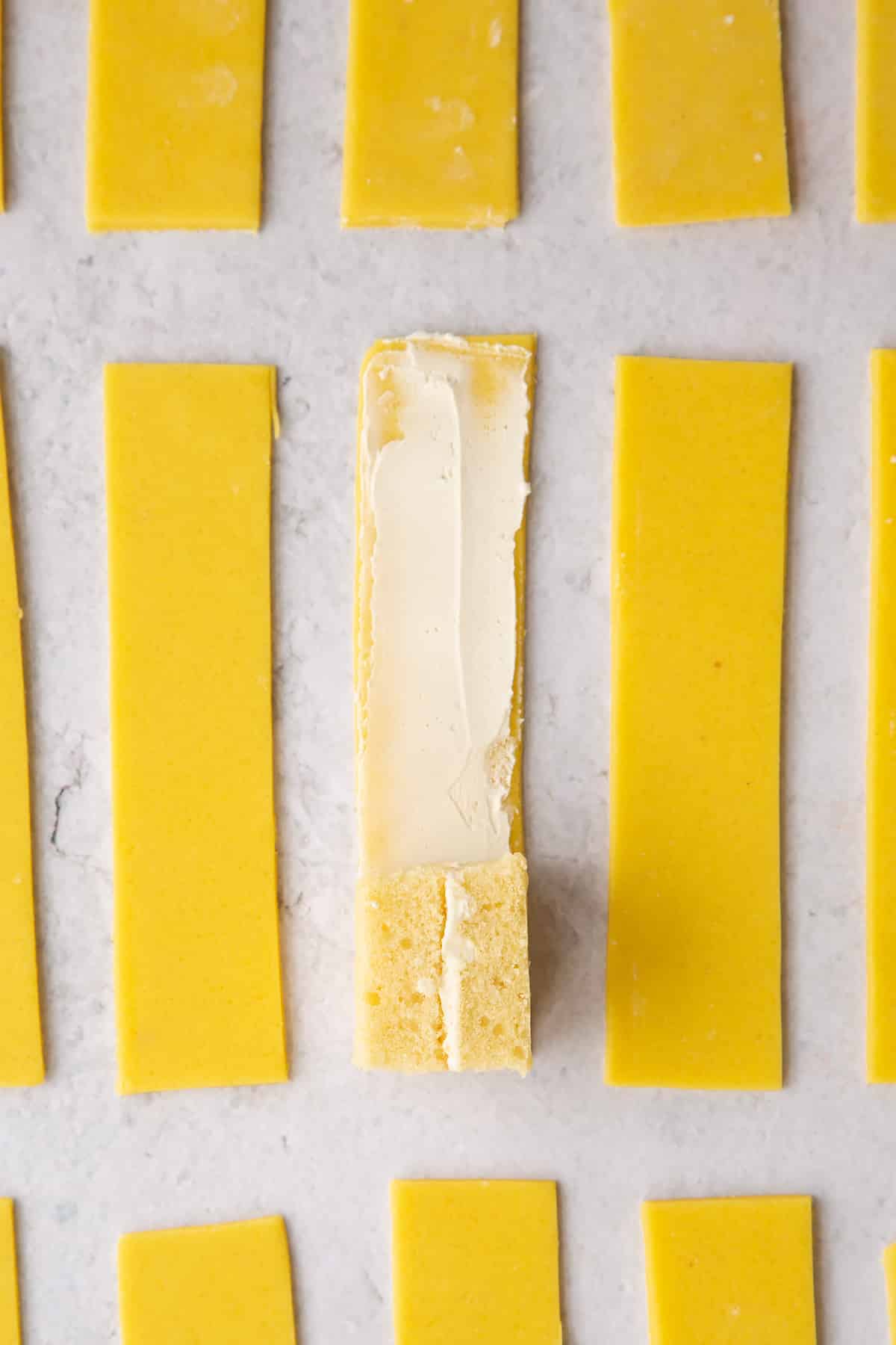 Placing a square of cake on the edge of the marzipan.