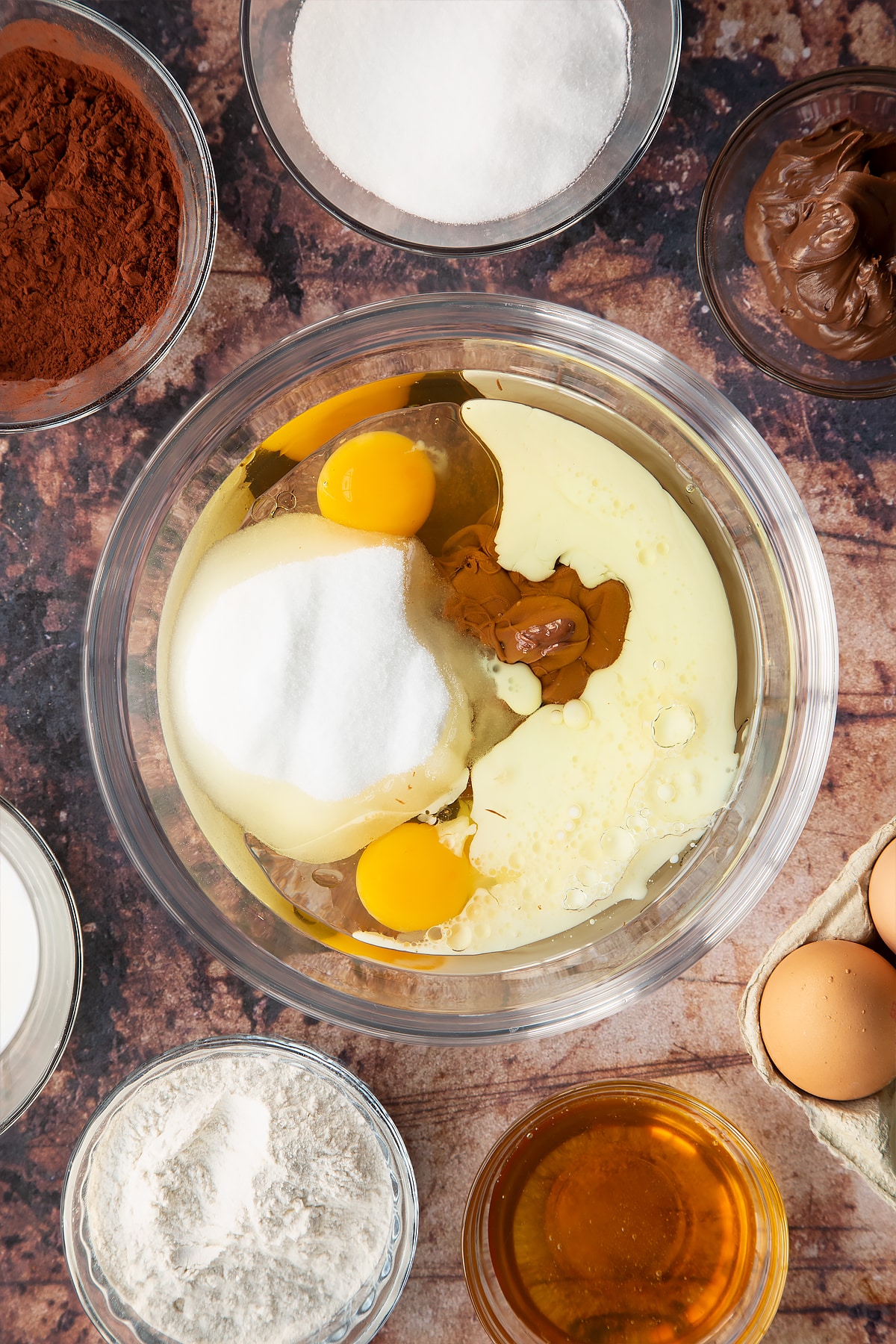vegetable oil, milk, golden syrup, Nutella, caster sugar and eggs in a large clear bowl.