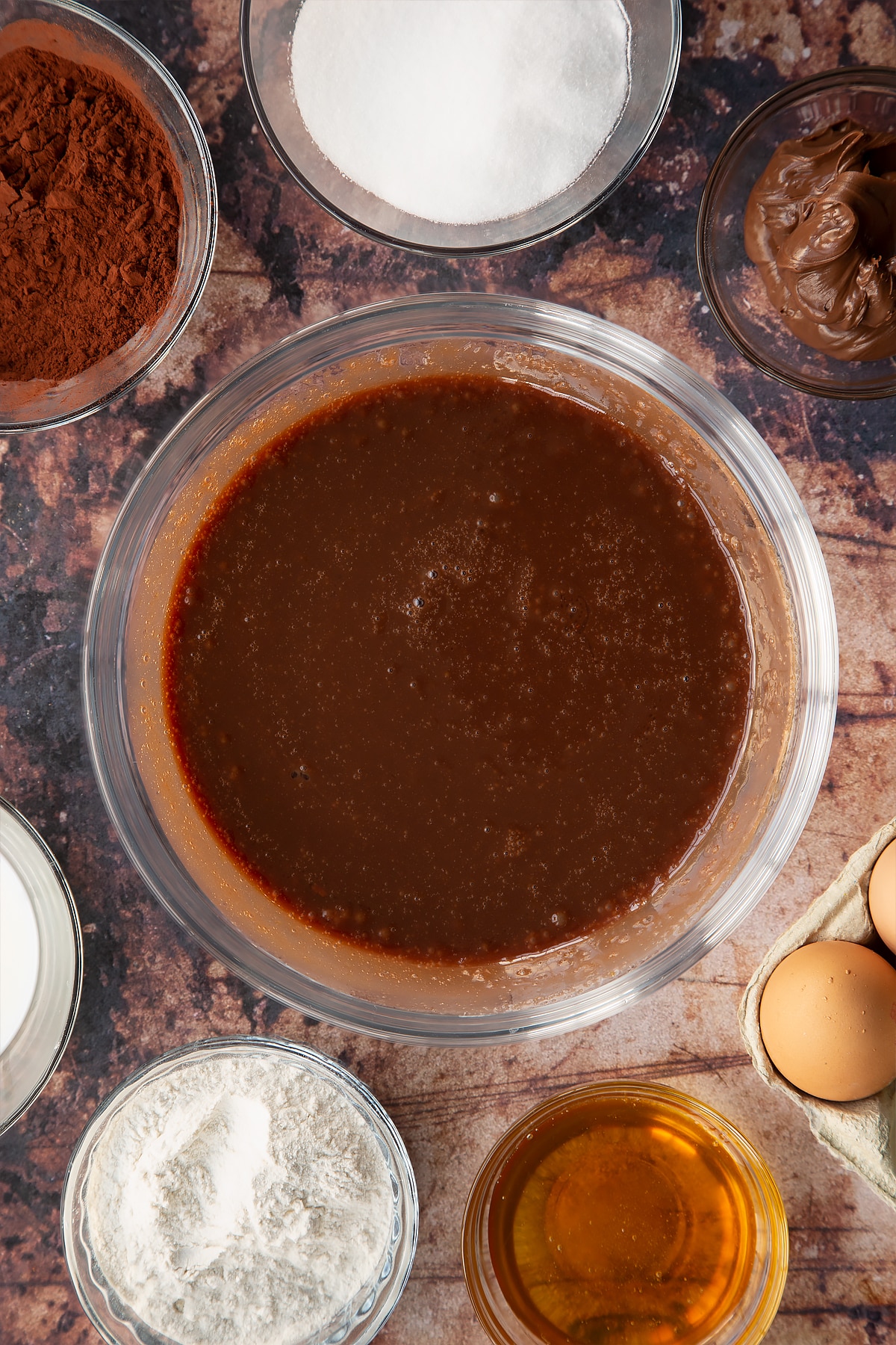 mixed vegetable oil, milk, golden syrup, Nutella, caster sugar and eggs in a large clear bowl.