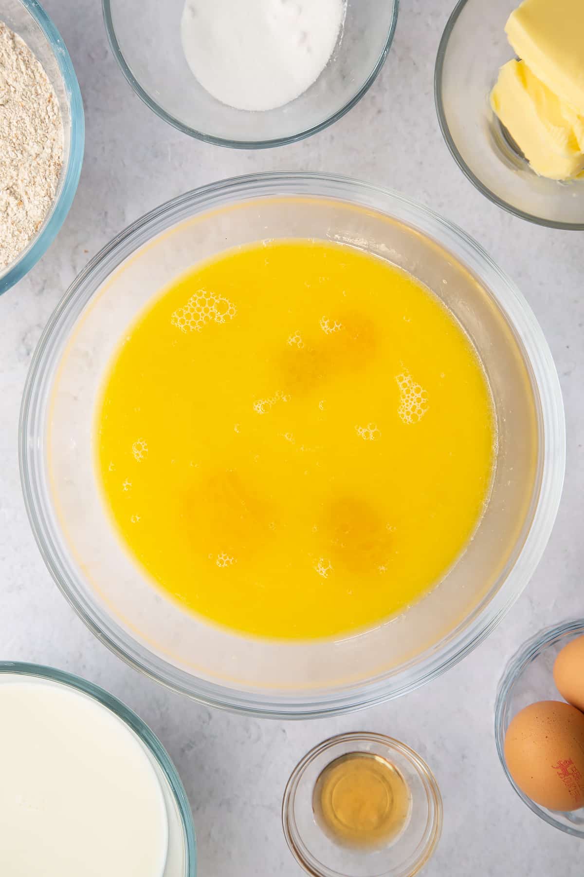 eggs, milk, melted butter and vanilla in a large clear bowl.