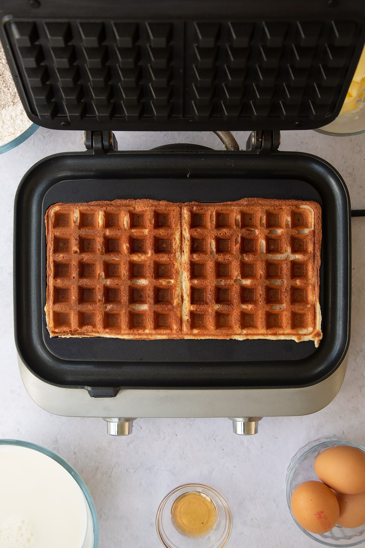 2 cooked wholemeal waffles in a waffle maker.
